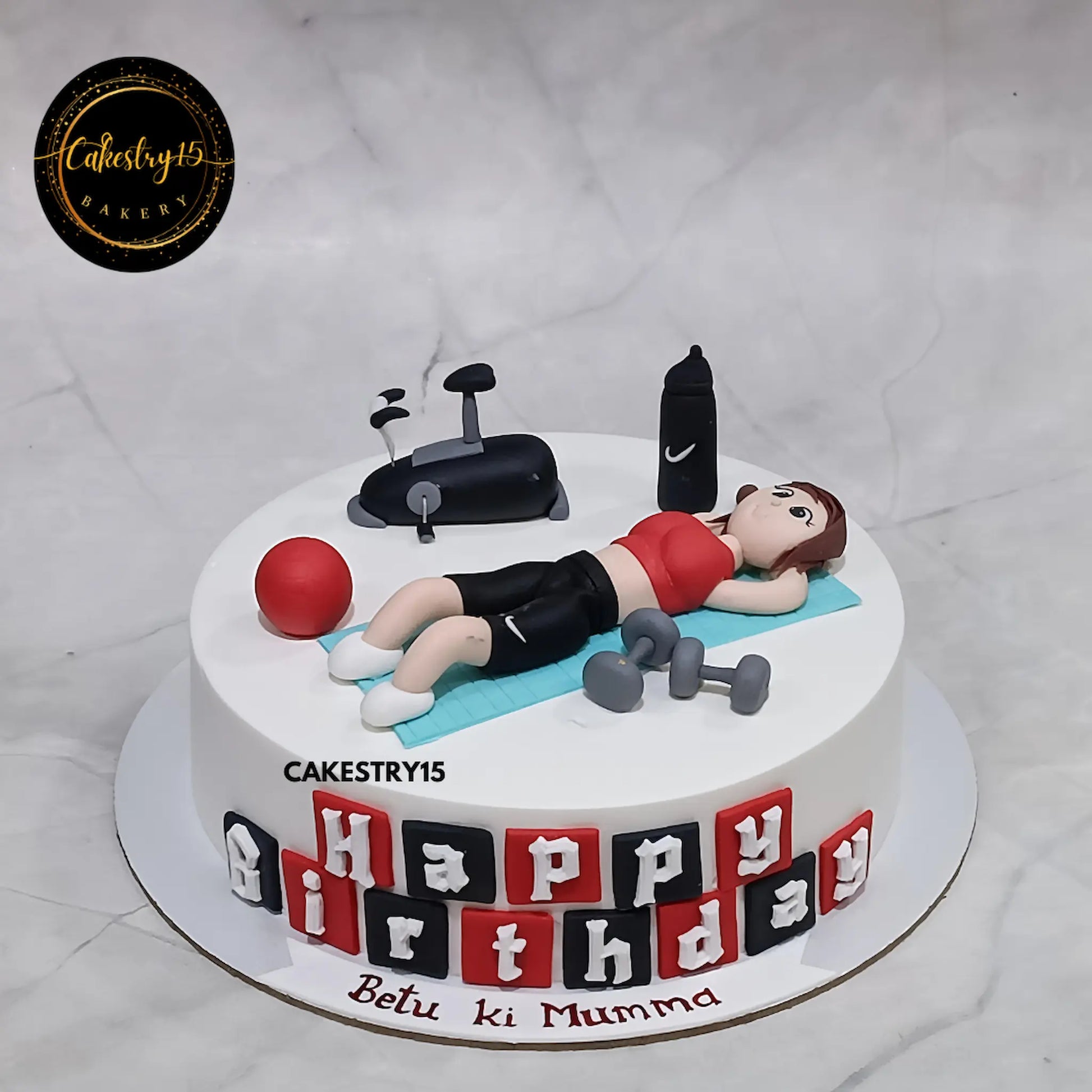 1kg chocolate gym-themed cake with fondant woman doing crunches, dumbbells, and birthday message