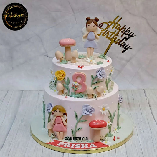 Fairy Blossom Delight,A two-tier chocolate fairy-themed birthday cake with girl figurines, fondant mushrooms, and flowers, made by Cakestry15 Noida.