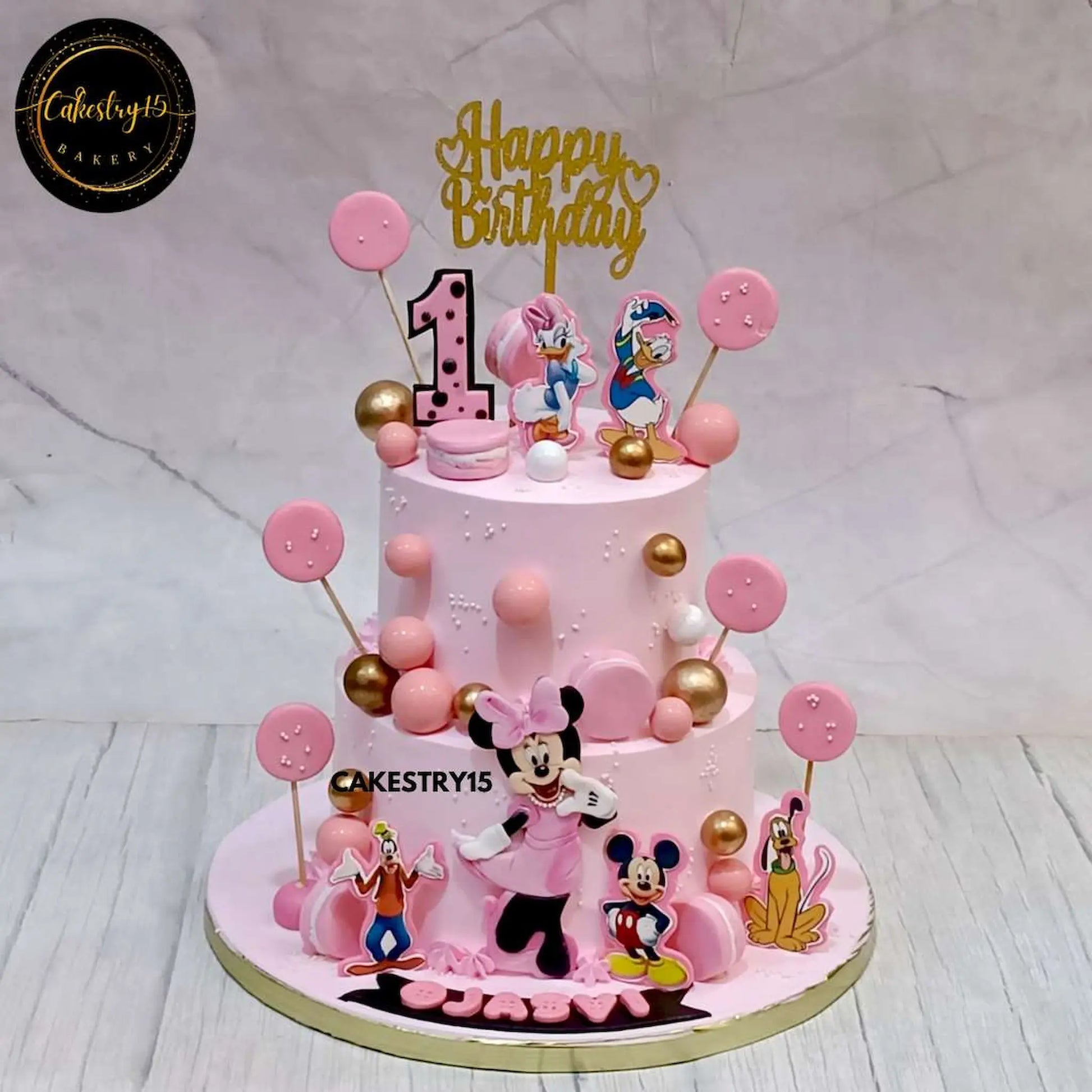 butterscotch birthday cake for Ojasvi’s 1st birthday, featuring edible Disney characters and pink decorations by cakestry15,best bakery noida