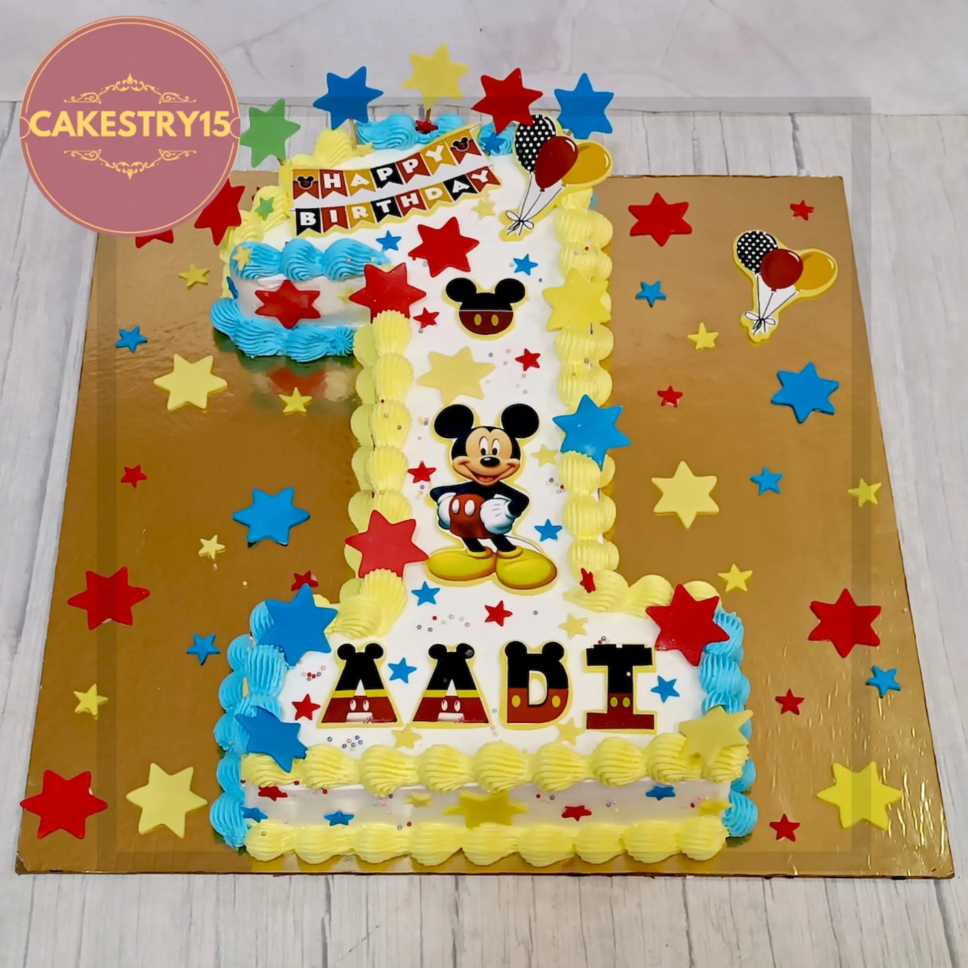 Aadi’s 2kg chocolate 1st birthday cake in digit 1 shape with Mickey Mouse edible images and fondant stars