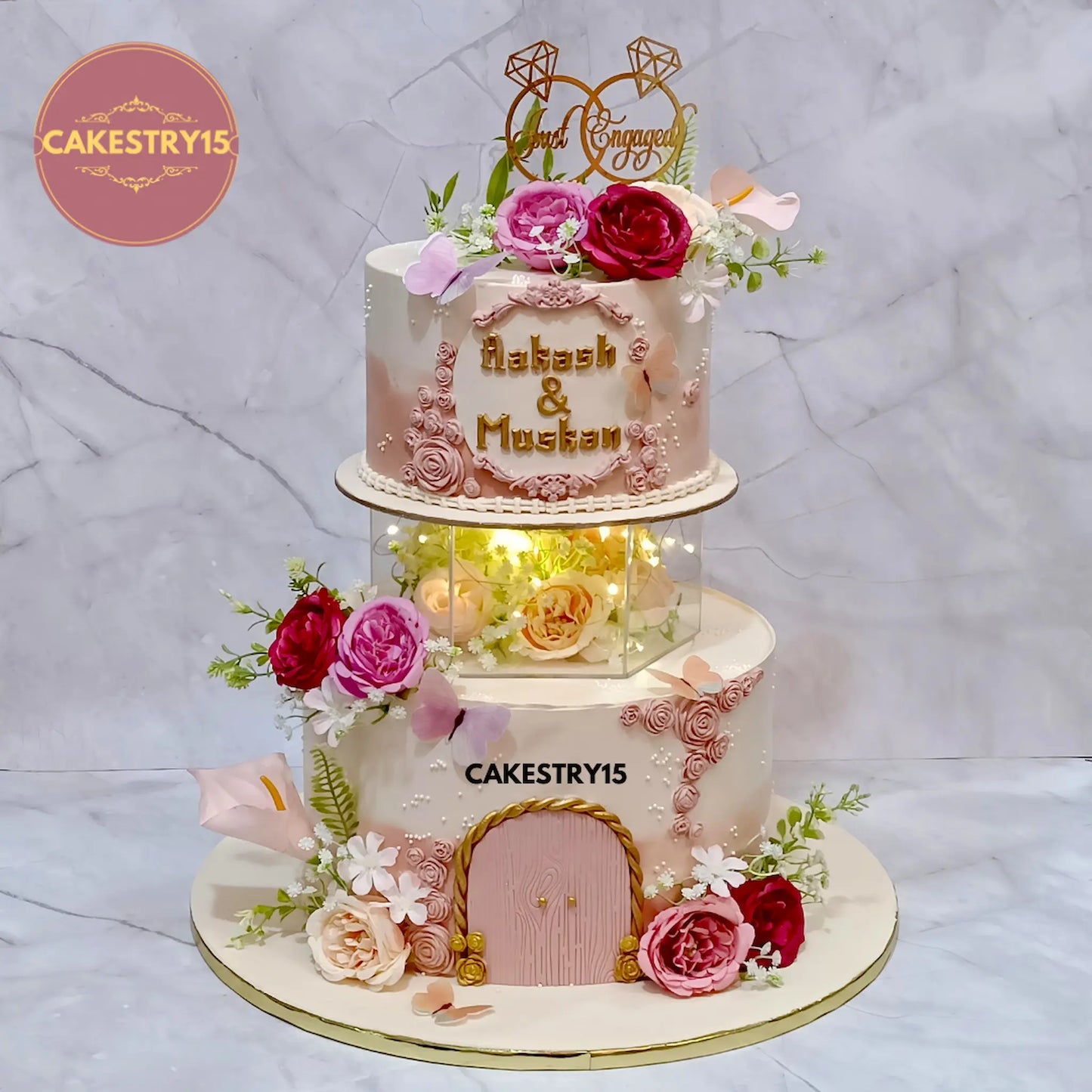 5kg chocolate engagement cake in peach and ivory with faux flowers, lights, and topper from Cakestry15 Noida