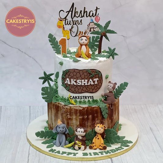 5kg chocolate jungle theme 1st birthday cake with baby boy topper, monkey, elephant, and giraffe from Cakestry15 Noida