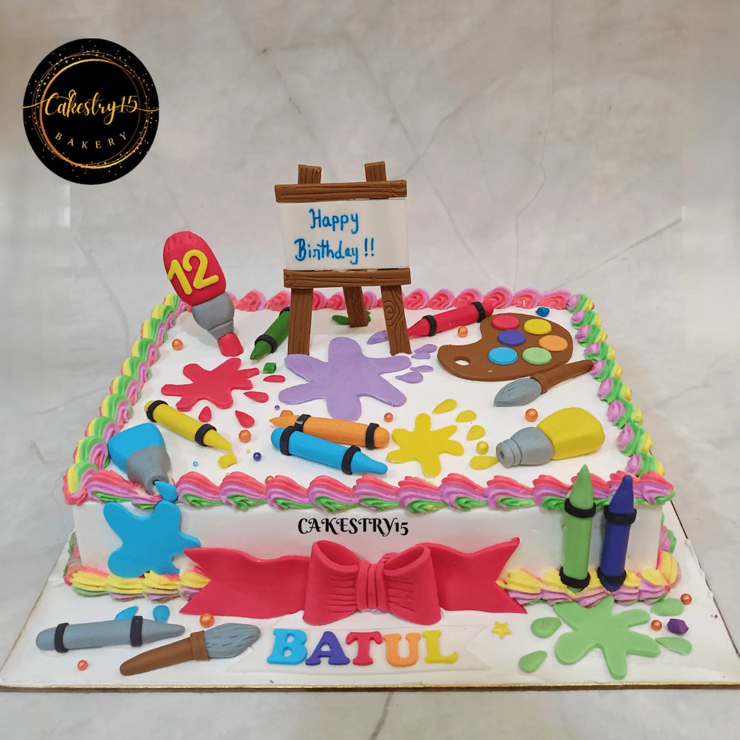 Eggless artist theme kids birthday cake in Noida with colourful fondant paint splashes and creative art design.