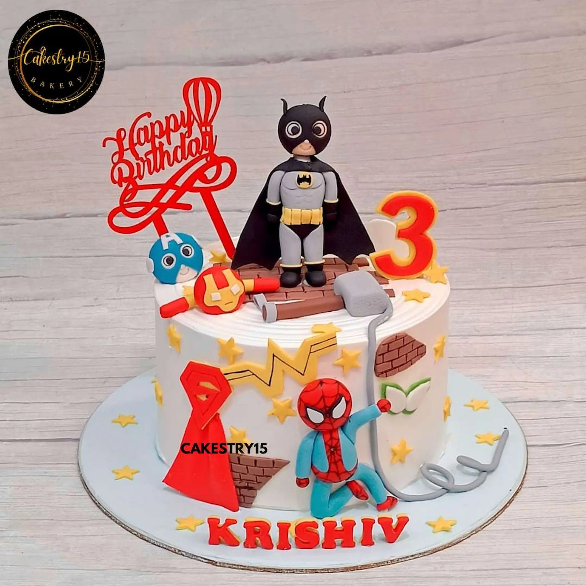 Avengers-themed 2kg pineapple cake with Batman, Spiderman, Iron Man, Captain America, and Thor’s hammer for a superhero birthday celebration by cakestry15 noida, best bakery noida
