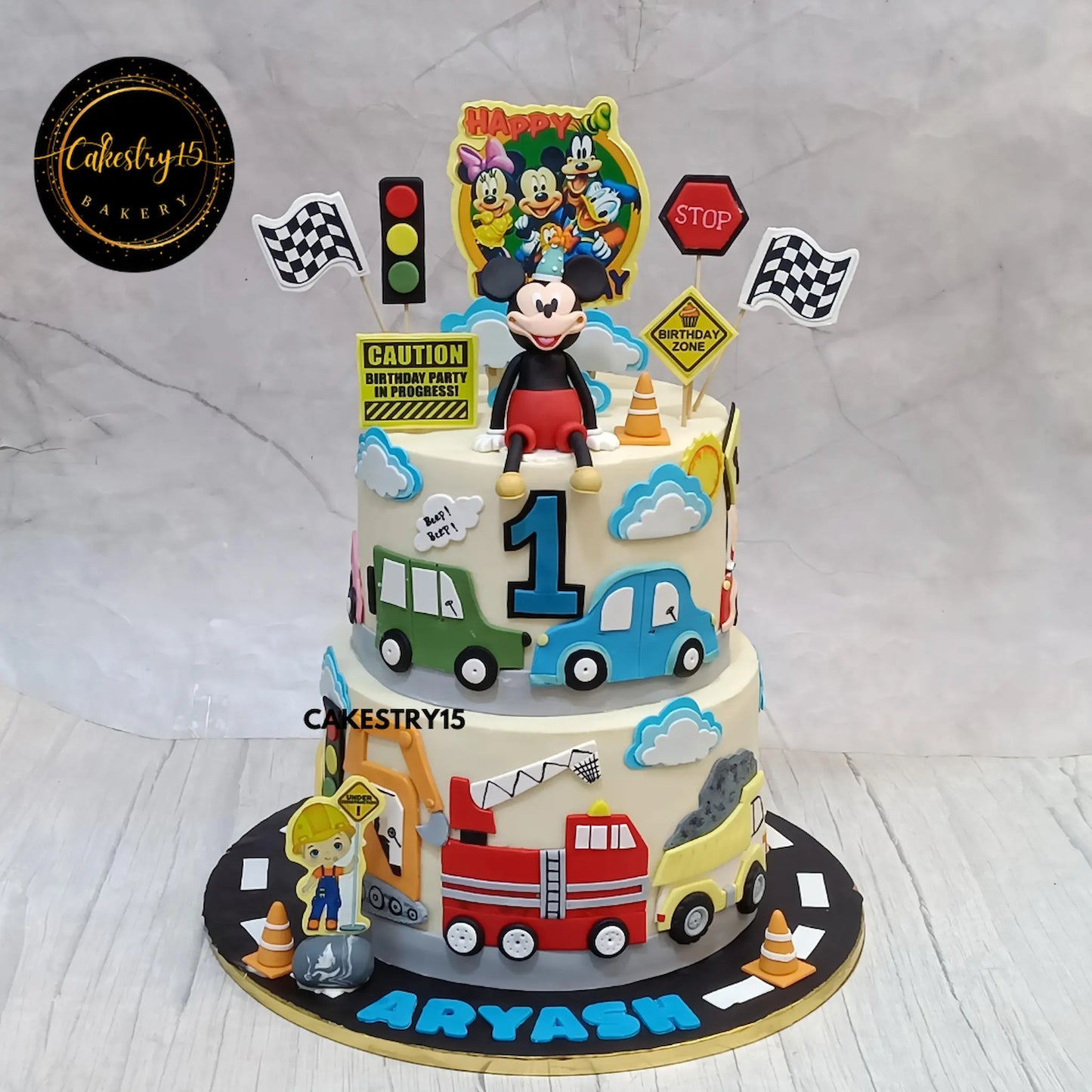 Car and Minnie theme eggless first birthday cake with choco chips flavour and white ganache finish by Cakestry15 in Noida