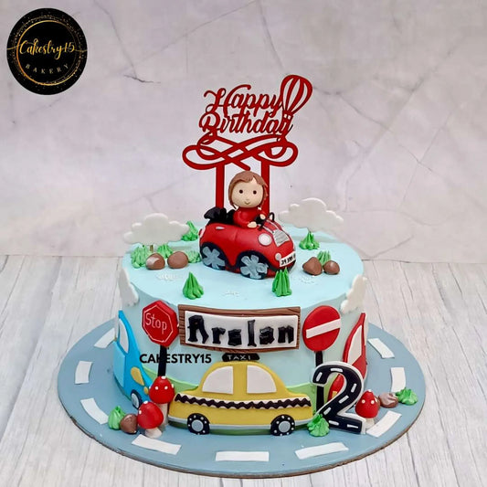 Car-themed birthday cake for Arslan’s 2nd birthday featuring a fondant boy in a 3D car, stop signs, 2D car decorations, and a road base by cakestry15 noida