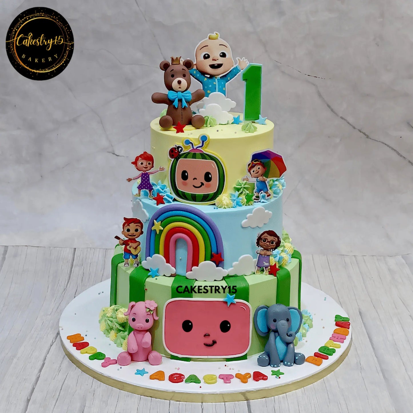3-tier chocolate Cocomelon theme birthday cake with fondant animals and rainbow by cakestry15 noida
