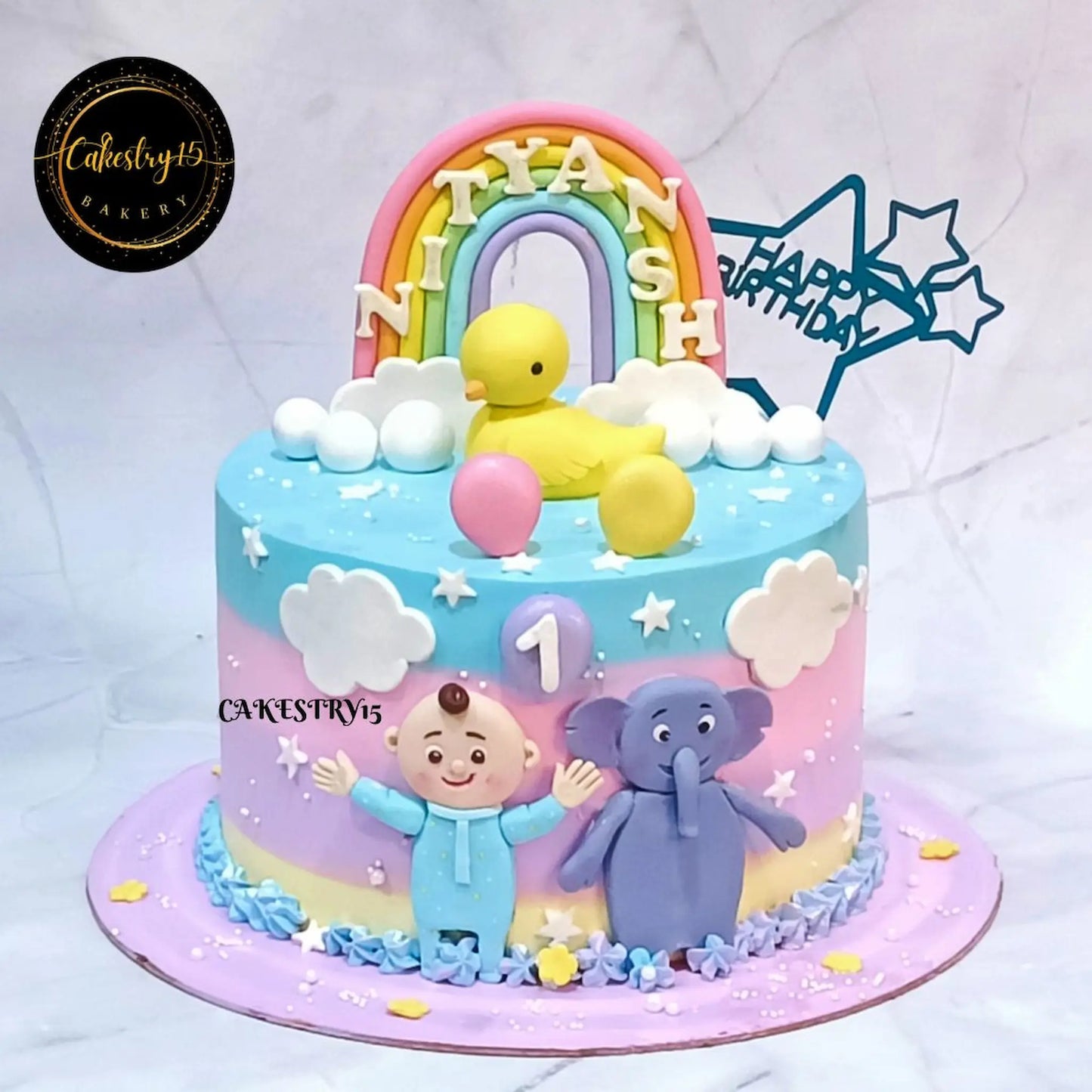 Eggless Cocomelon and elephant first birthday cake with rainbow, duck and fondant decorations for kids birthday in Noida