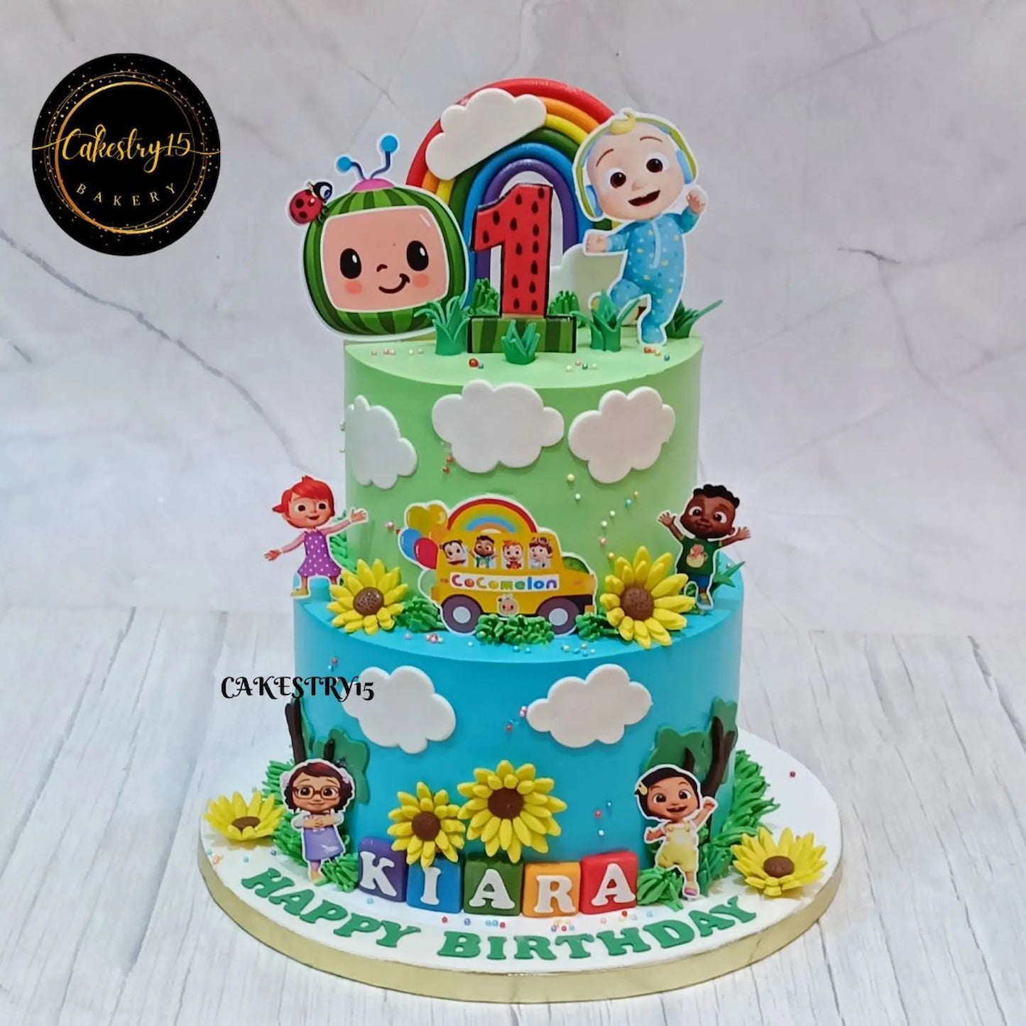 Eggless cocomelon magic theme first birthday cake with rainbow and sunflower design for kids birthday celebration in Noida