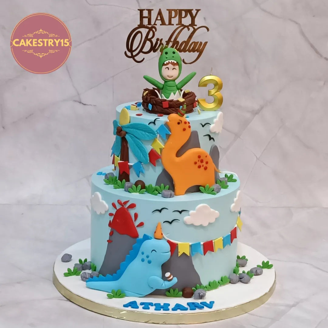 Eggless dino jungle theme kids birthday cake in Noida with fondant dinosaurs and custom 2-tier design for boys celebration.