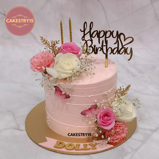 Dolly floral 1kg pineapple birthday cake topped with fresh roses, golden candles, and butterflies by cakestry15 in noida
