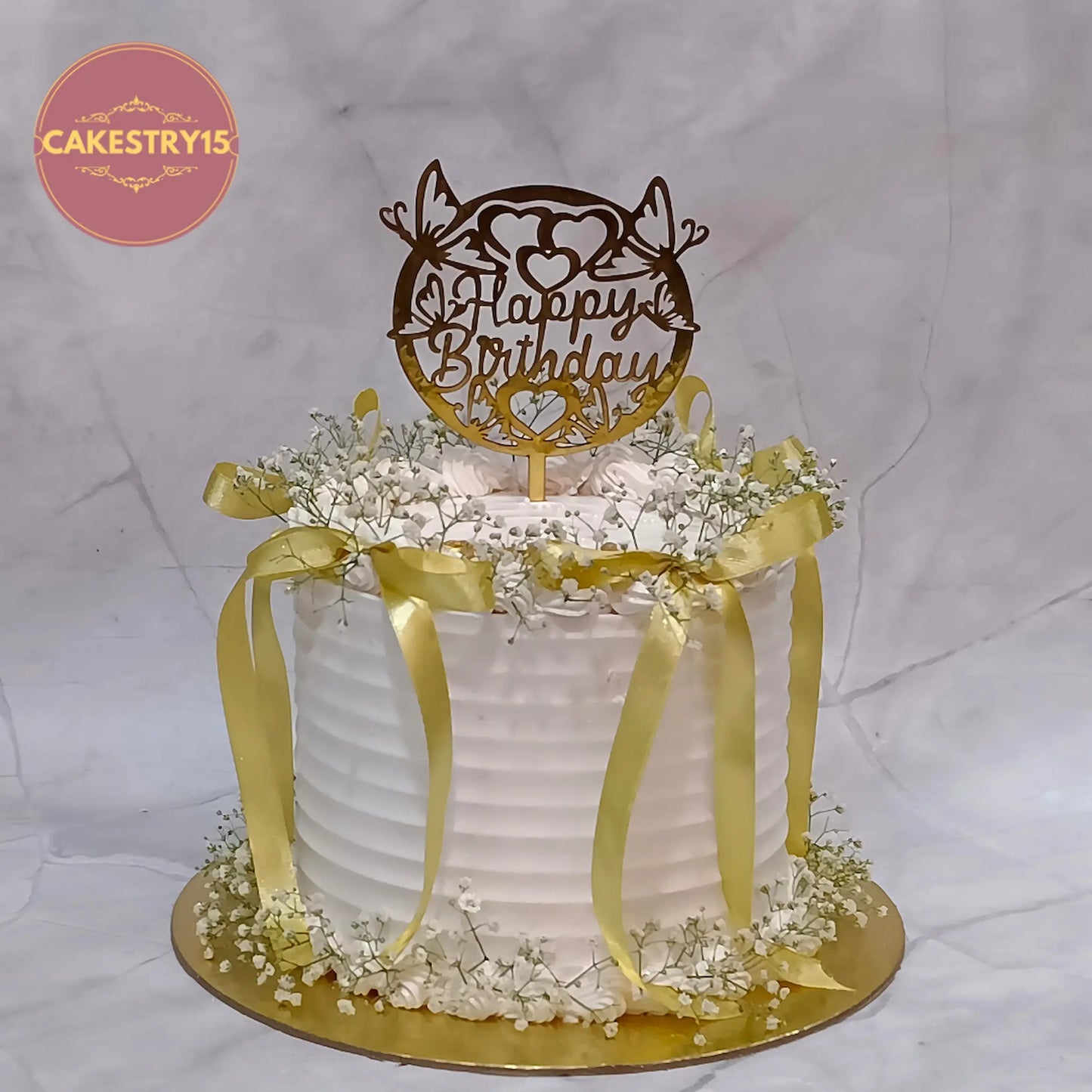 Elegant floral eggless butterscotch birthday cake for wife with baby breath flowers and golden ribbon by Cakestry15 in Noida