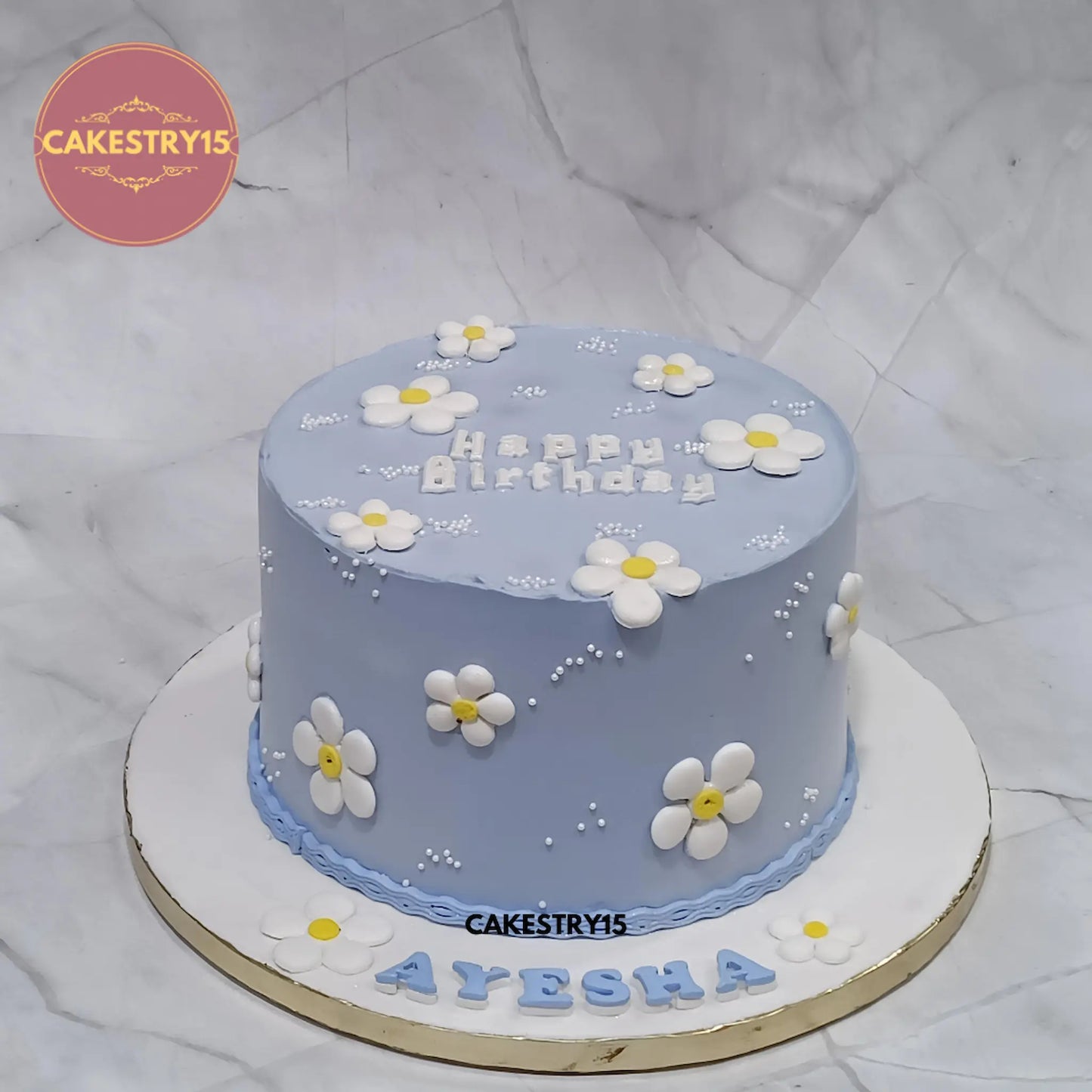 Elegant floral kids birthday cake with blue icing and white fondant flowers, perfect as a theme cake Noida design from Cakestry15 eggless cakes collection.