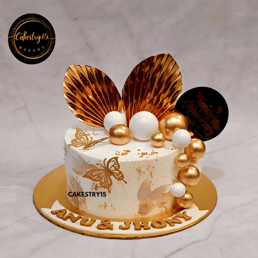 Golden anniversary butterscotch cake with ferns, golden butterflies, and faux balls by cakestry15,best bakery noida
