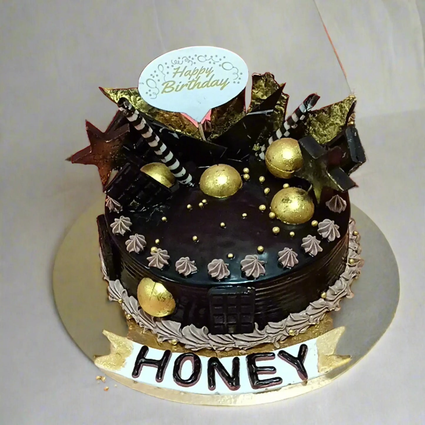 1kg chocolate birthday cake with golden balls and honey name tag by cakestry15 noida