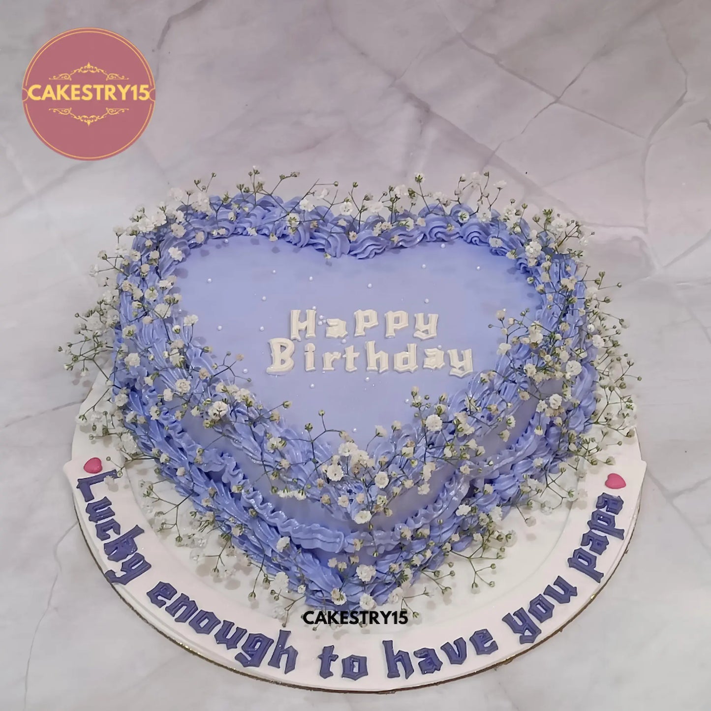 Eggless papa birthday heart-shaped pineapple cake with blue icing and baby breath flowers from Cakestry15 Noida