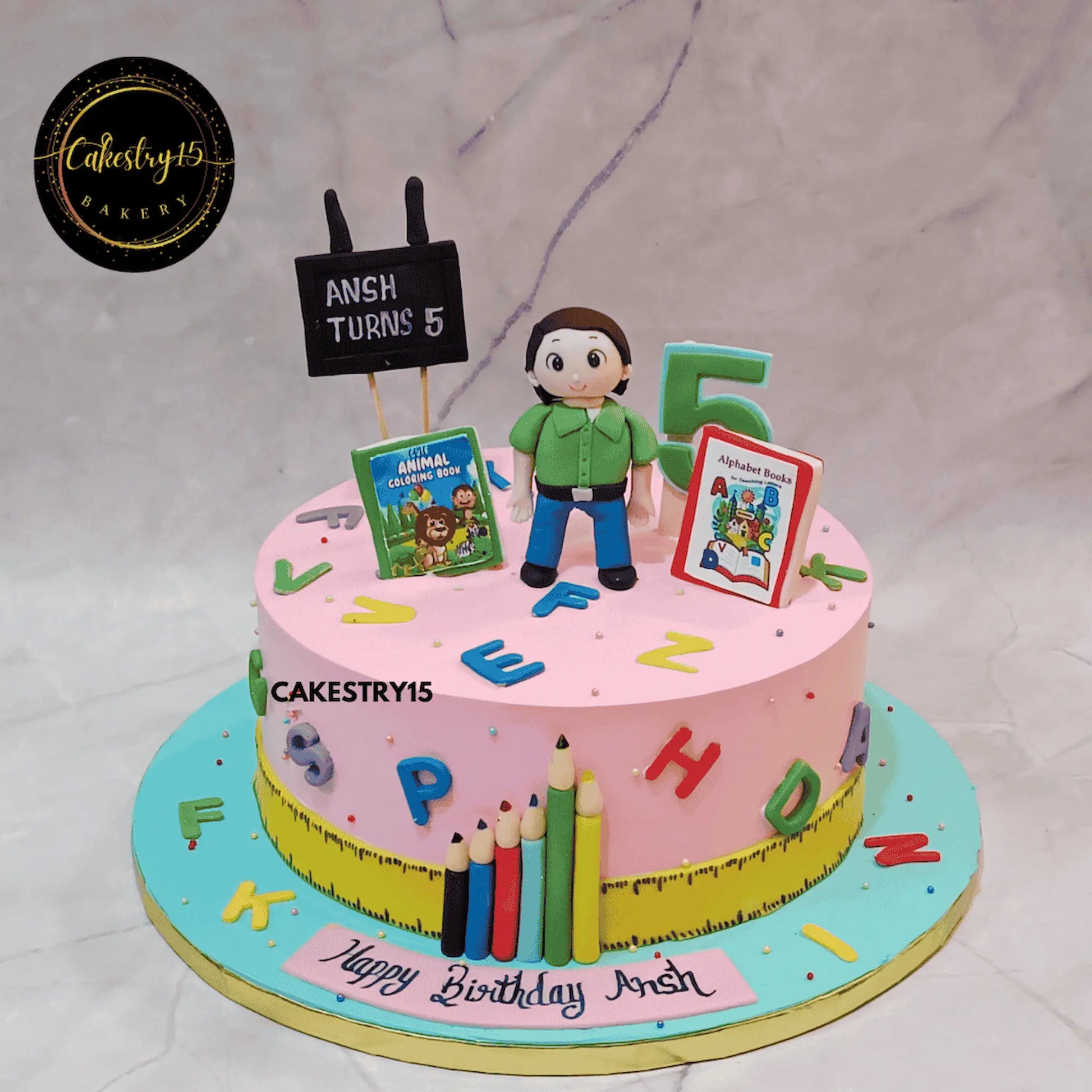 A 2kg chocolate birthday cake with a boy figurine, school books, blackboard, crayons, ruler, and colorful alphabets for Ansh’s 5th birthday by cakestry15 noida