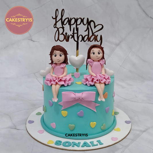 1kg chocolate birthday cake topped with two girl figurines and heart decorations