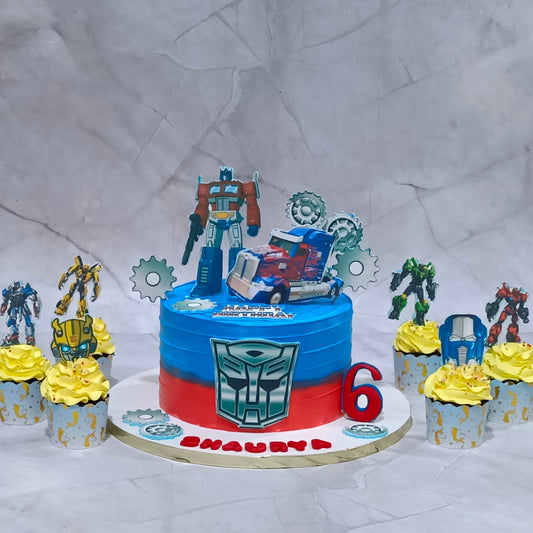 Eggless Transformers theme cake with six matching cupcakes displayed for a kids birthday cake setup in Noida.