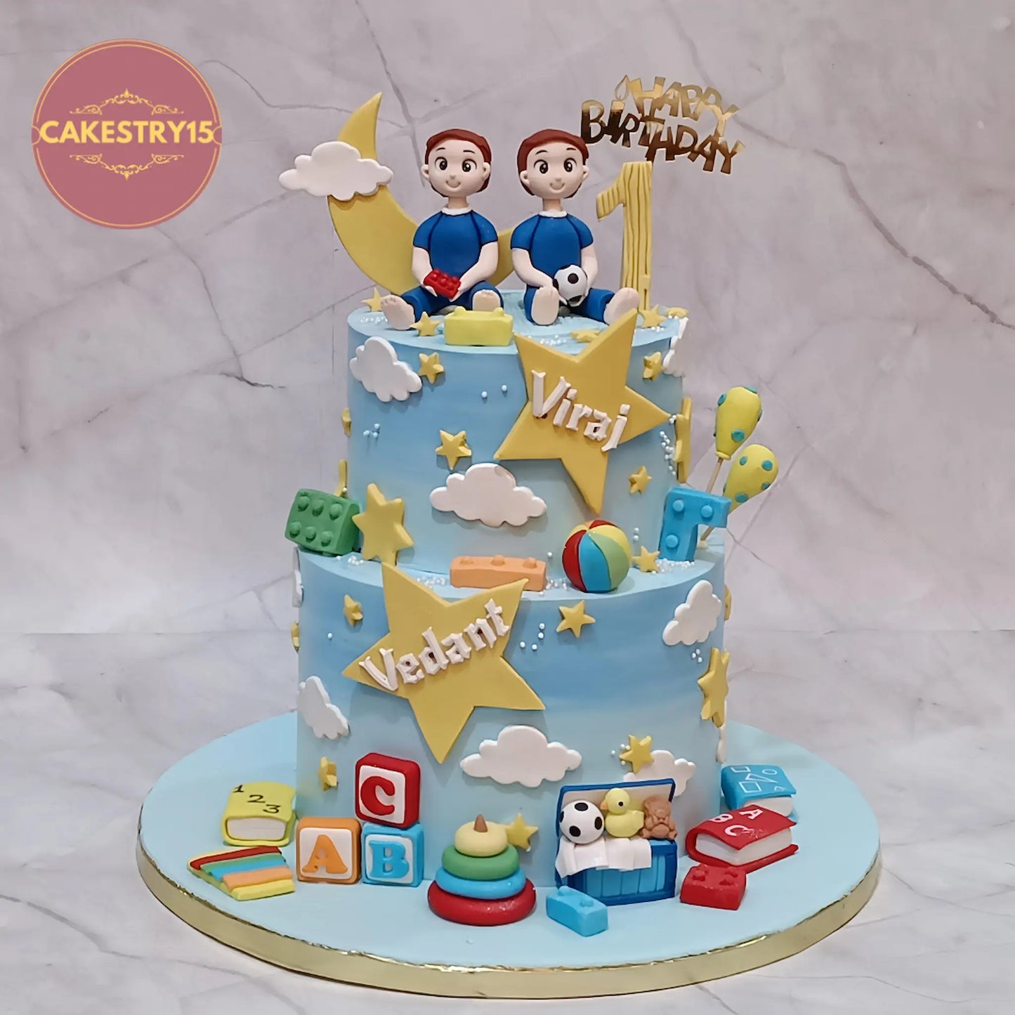 Eggless twin boys first birthday cake with figurines, stars and toys in choco vanilla flavour by Cakestry15 Noida