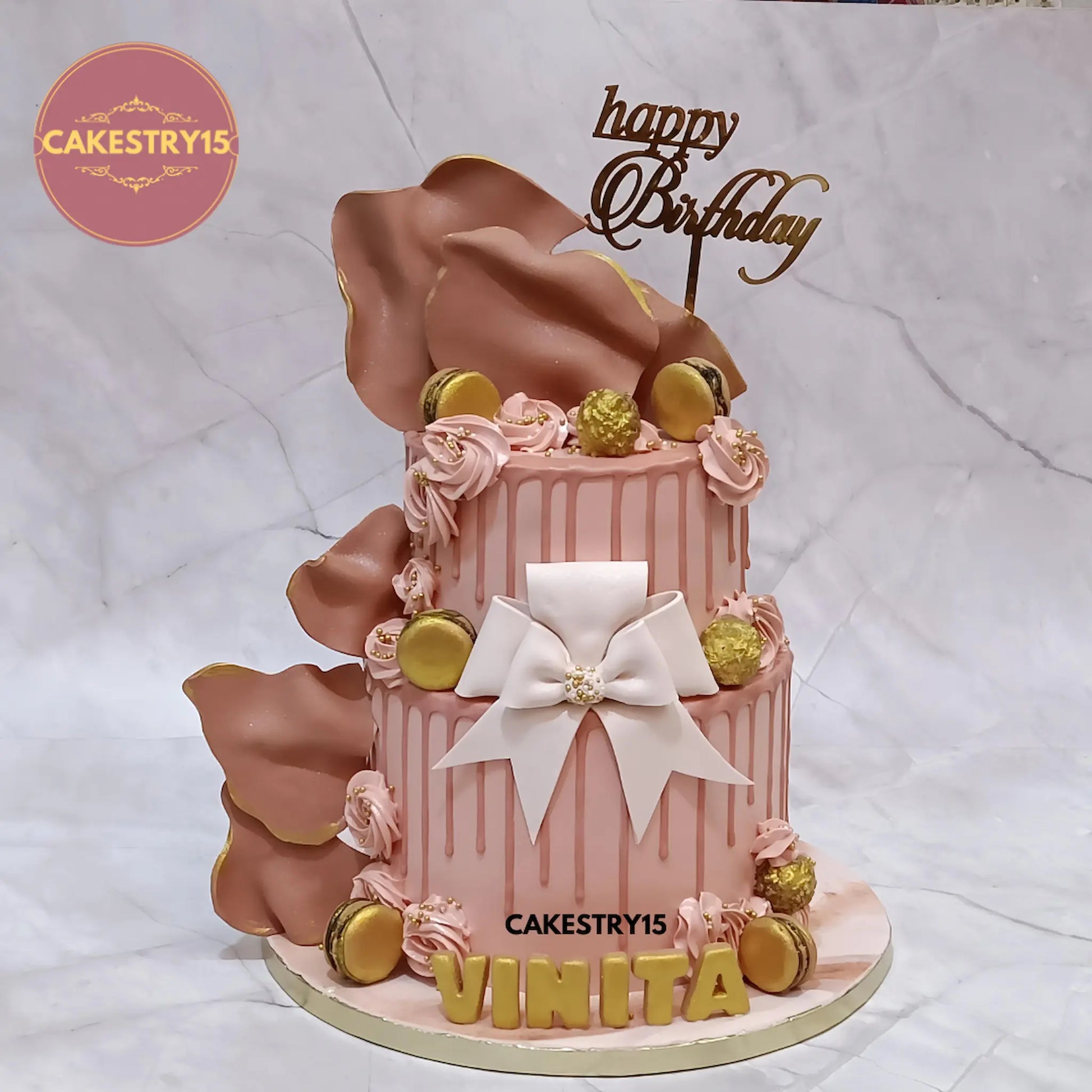 3kg eggless choco vanilla birthday cake with fondant sails, bow, Ferrero Rocher, macarons, cream rosettes, and 3D name base from Cakestry15
