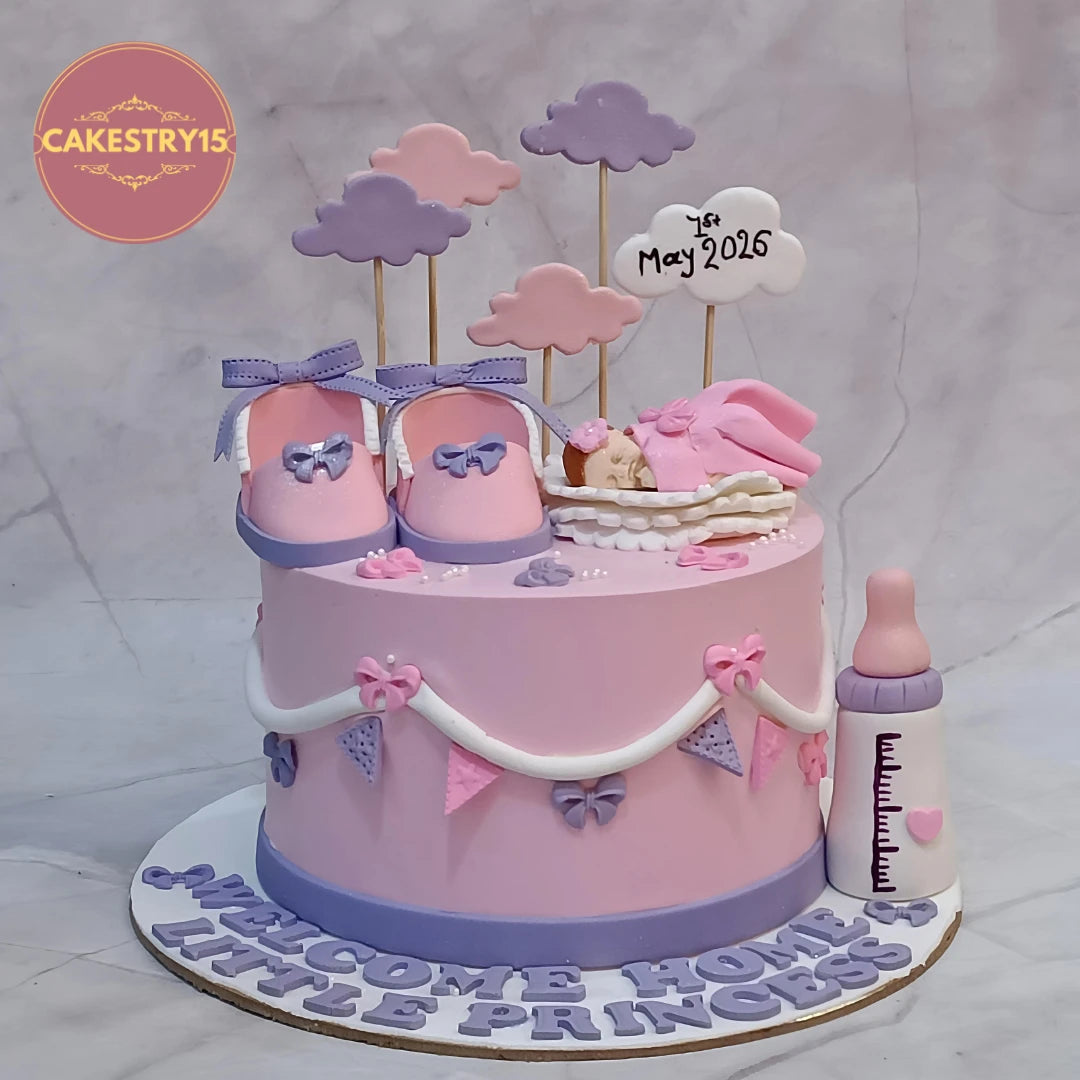 Welcome Baby Girl kids birthday cake featuring a sleeping baby figurine, baby shoes, clouds and milk bottle, handcrafted as a theme cake Noida using premium eggless cakes.