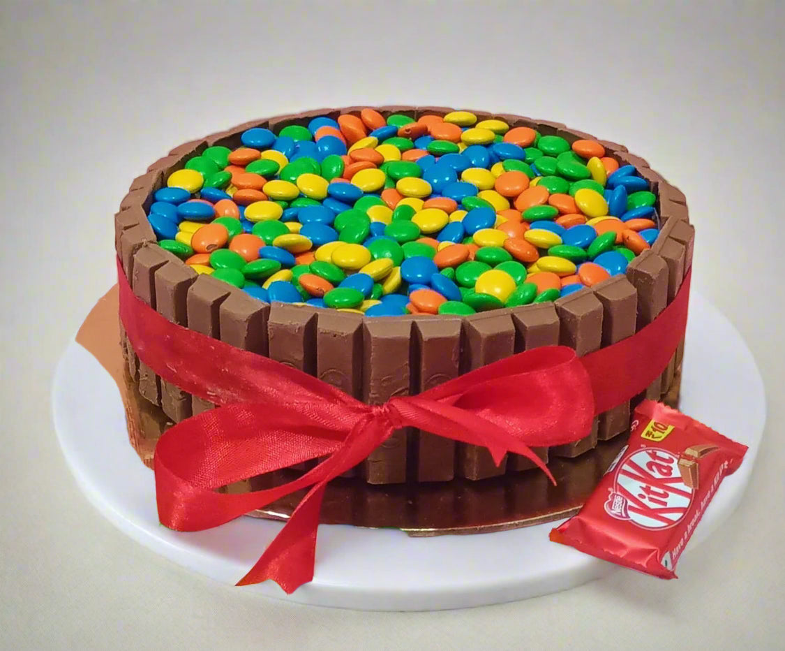 Chocolate KitKat cake layered with ganache, topped with gems, from Cakestry15 Noida