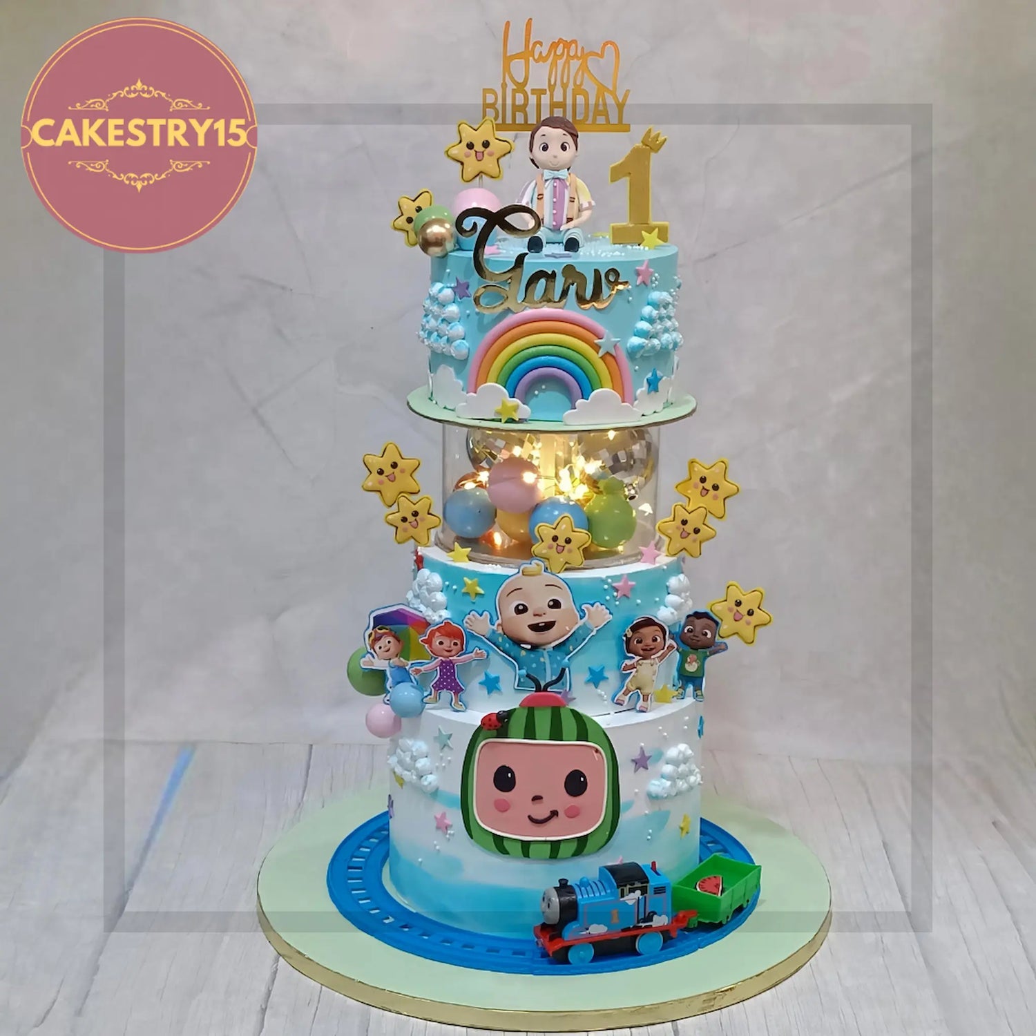 Cocomelon theme cake with JJ, Cody, YoYo and colorful balloons