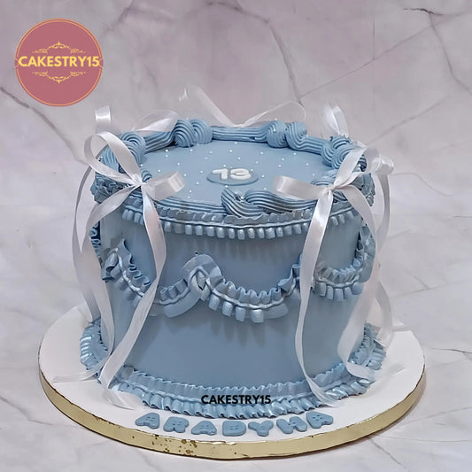 2kg chocolate ribbon birthday cake for Aradhya, topped with cream piping and satin bows, made by Cakestry15 Noida