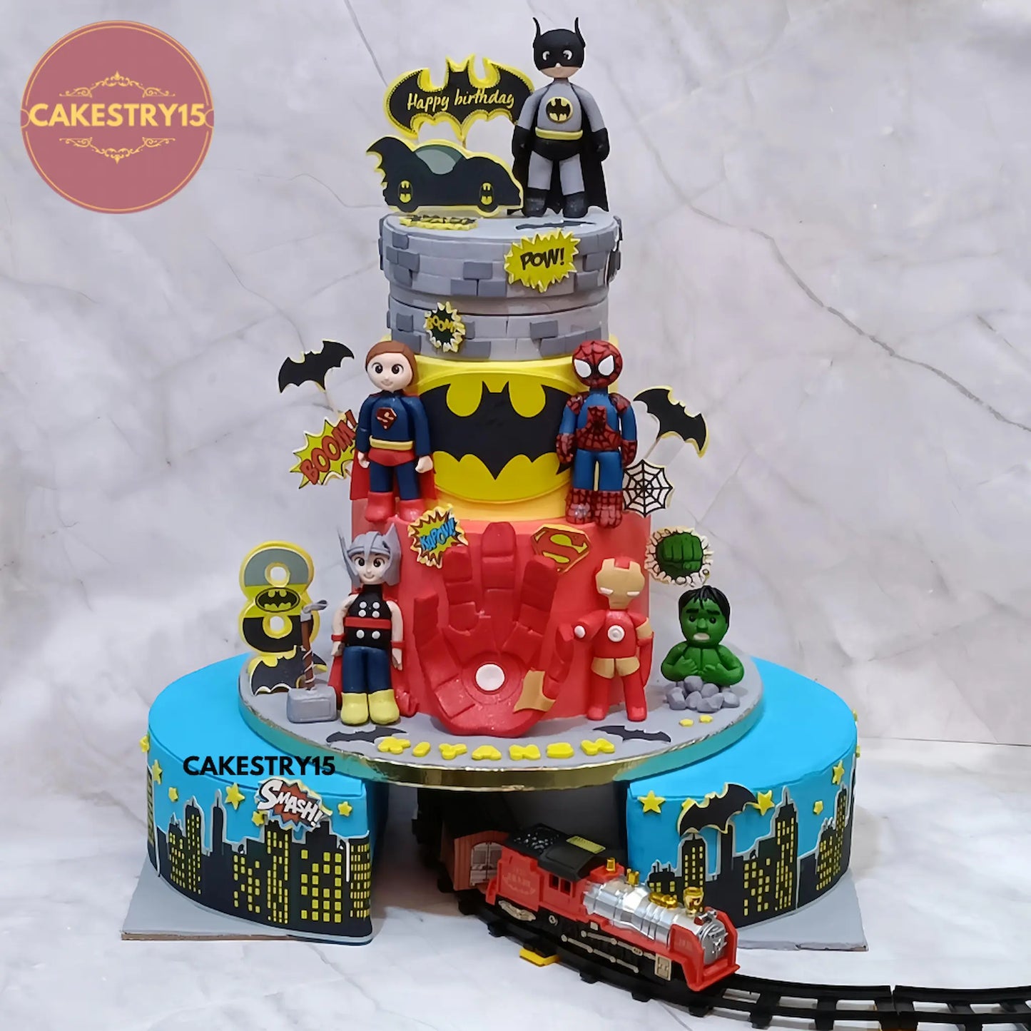 4kg chocolate superheroes theme birthday cake with rotator, cityscape base, fondant figurines by Cakestry15 Noida.