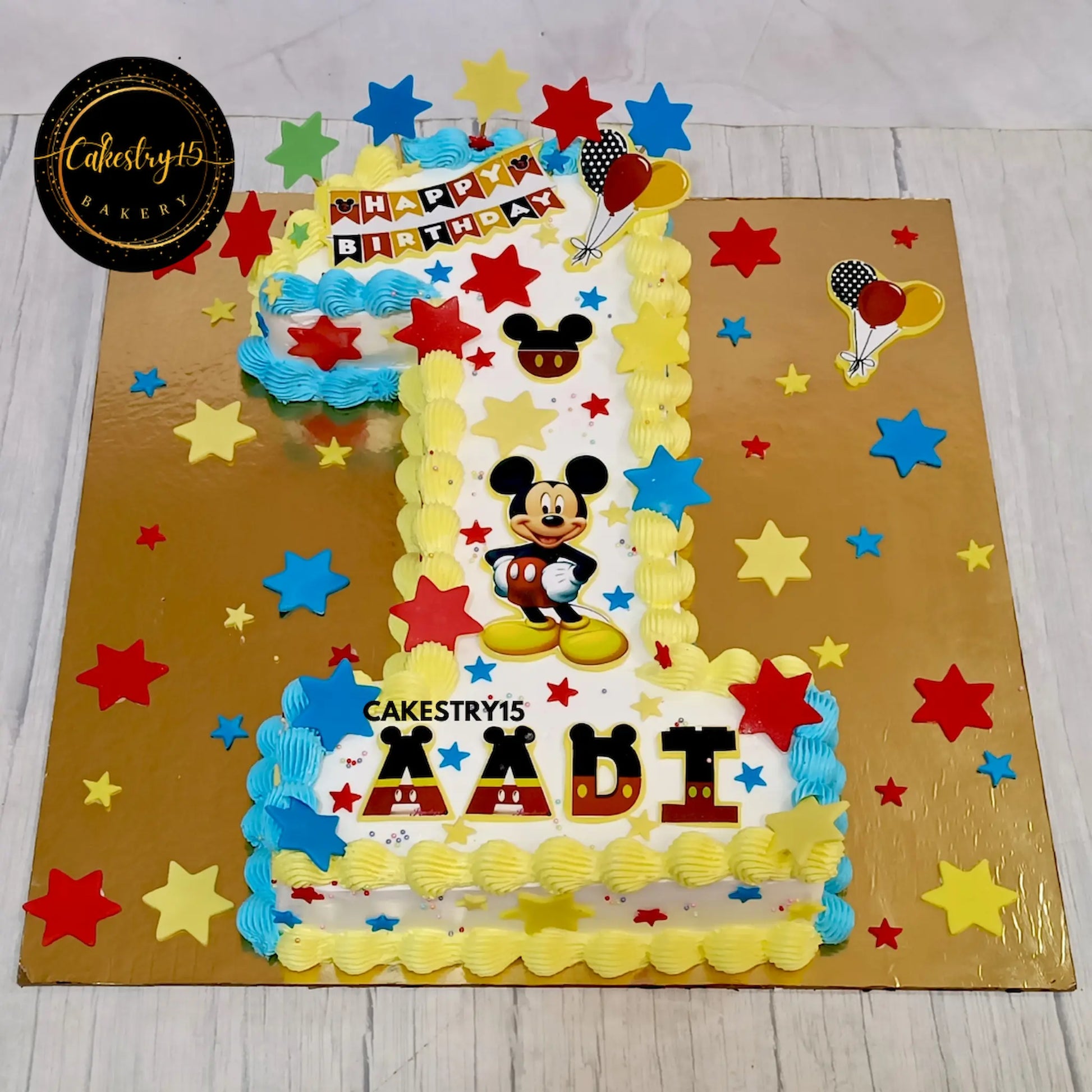 Aadi’s 2kg chocolate 1st birthday cake in digit 1 shape with Mickey Mouse edible images and fondant stars