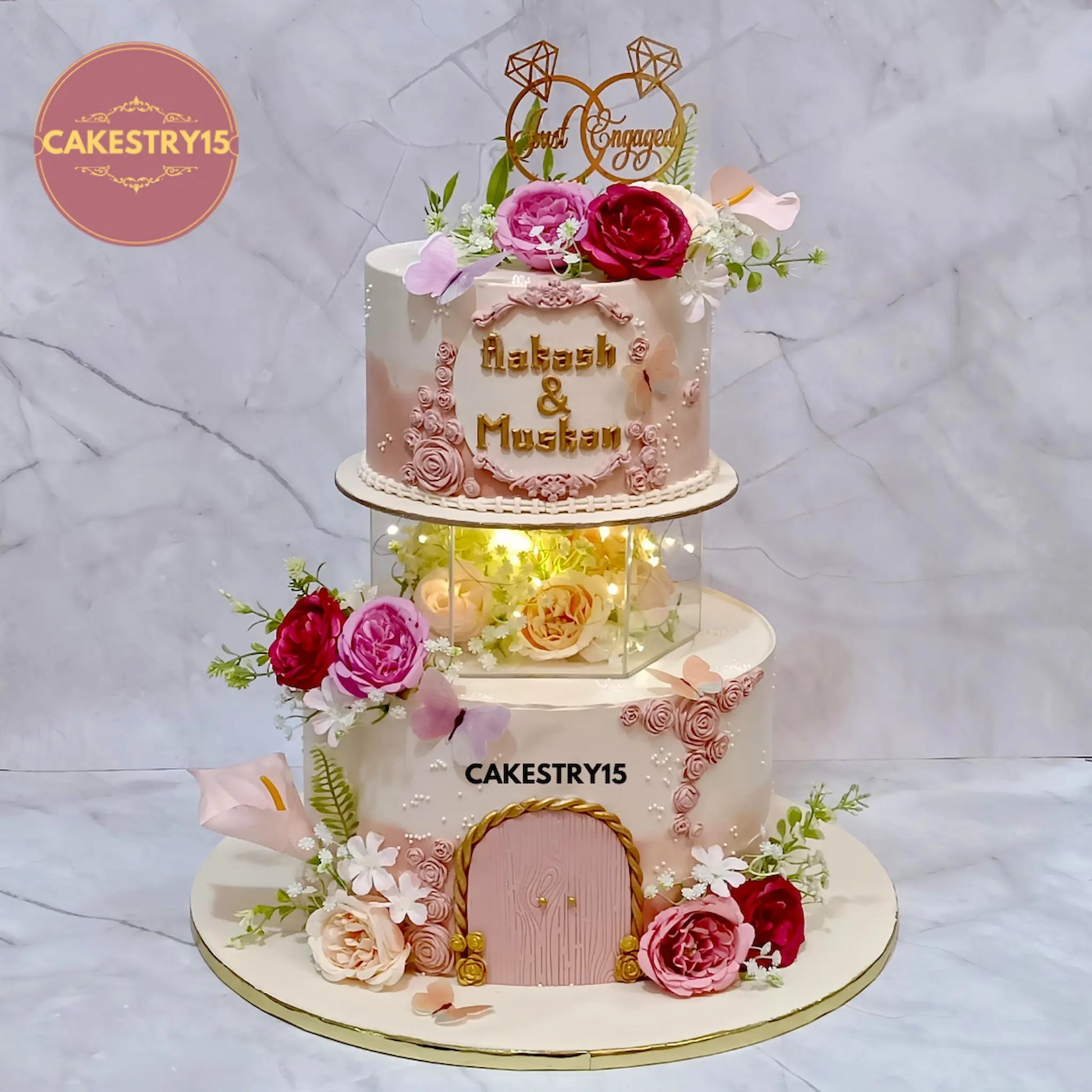 5kg chocolate engagement cake in peach and ivory with faux flowers, lights, and topper from Cakestry15 Noida
