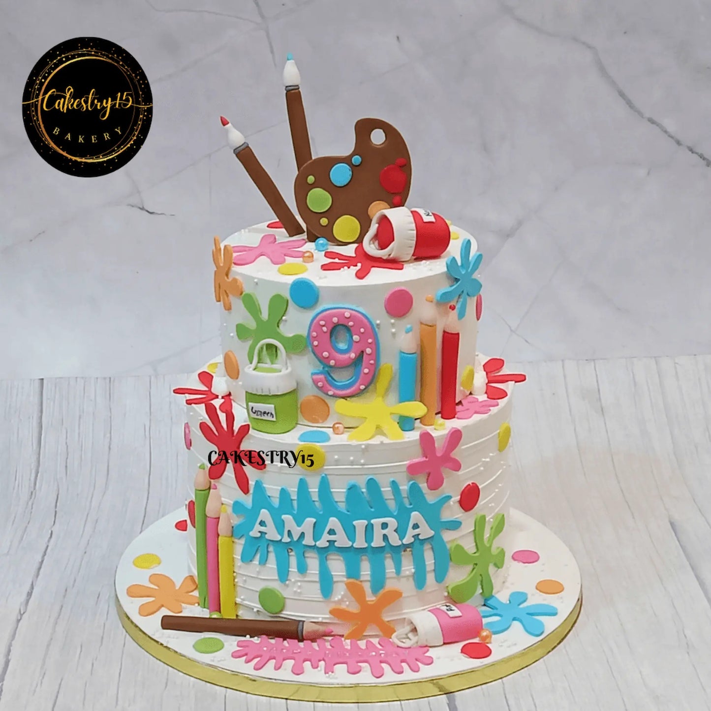 Eggless artist theme kids birthday cake Noida with blueberry flavour, fondant brushes, pencils and colourful creative detailing.