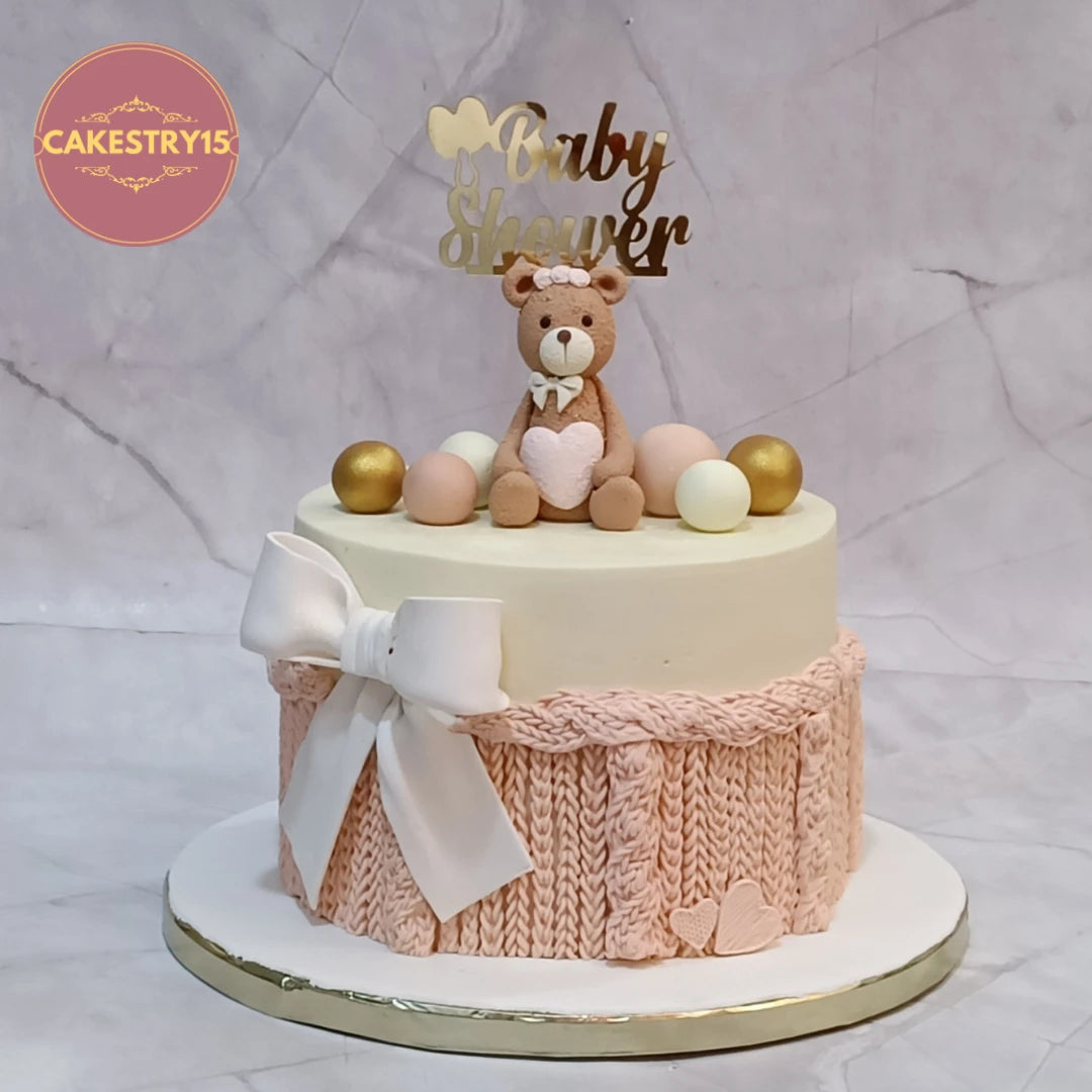 Baby Shower Teddy Love Cake featuring a teddy topper and knitted fondant details, a premium theme cake Noida design made with fresh eggless cakes.