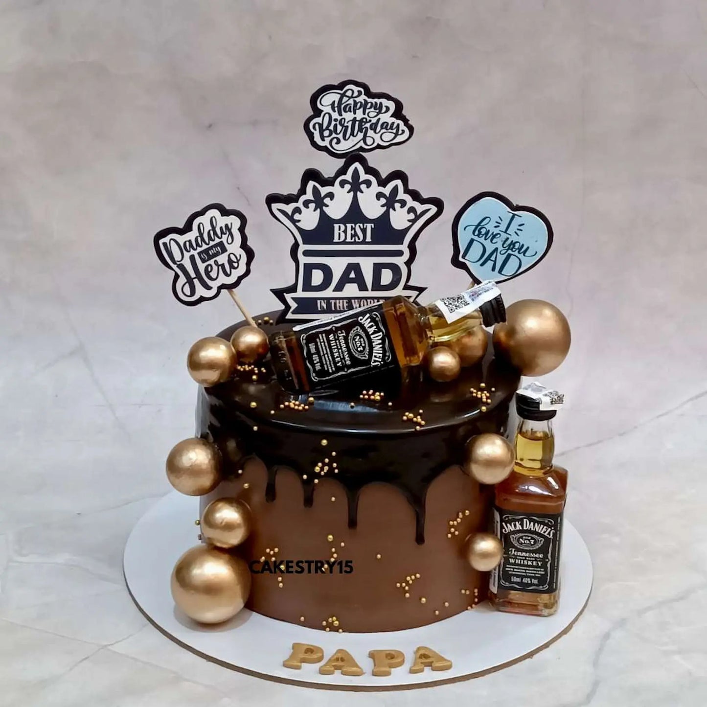1kg chocolate birthday cake for dad with chocolate drip, golden balls, Jack Daniels miniatures and edible birthday messages by cakestry15,best bakery in noida