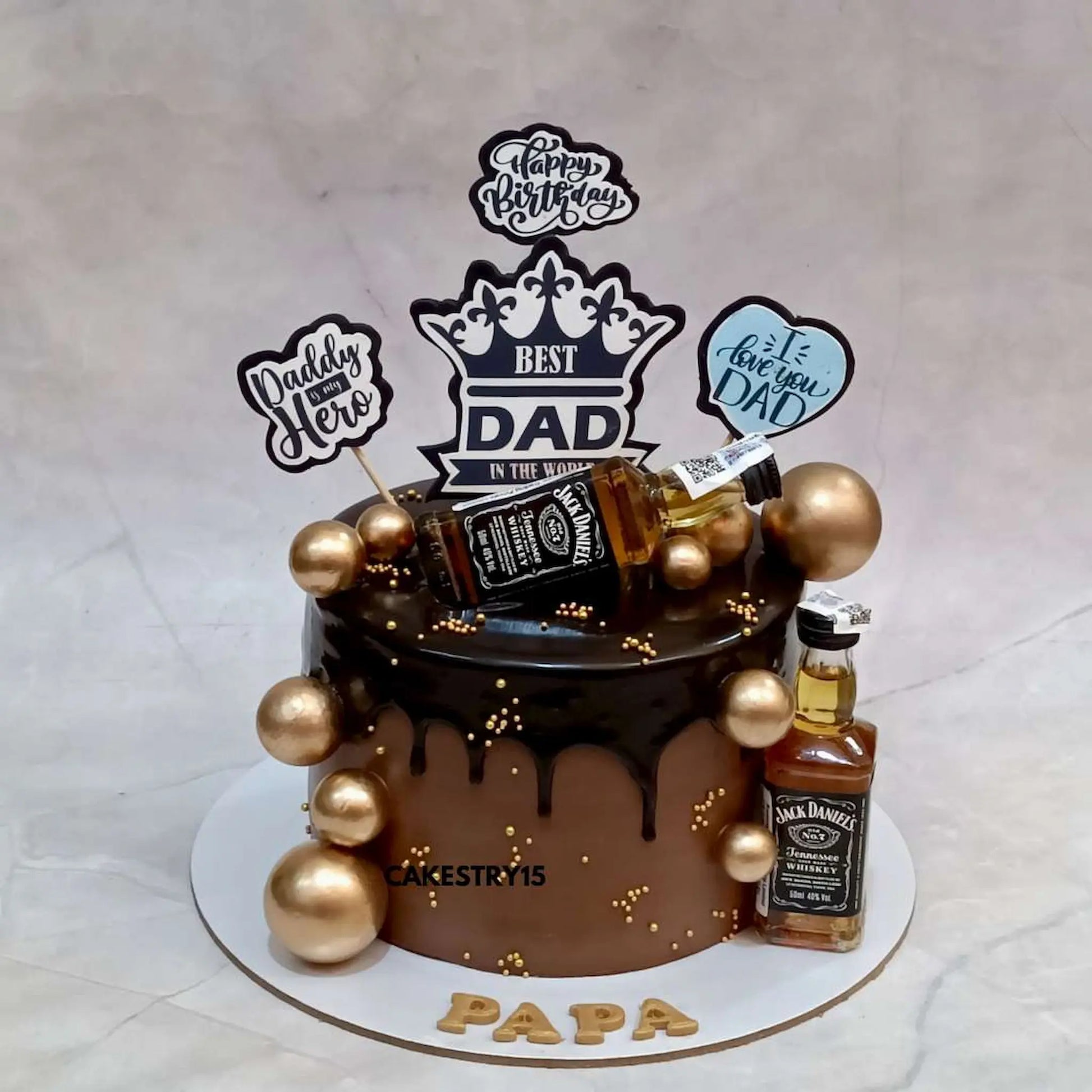 1kg chocolate birthday cake for dad with chocolate drip, golden balls, Jack Daniels miniatures and edible birthday messages by cakestry15,best bakery in noida