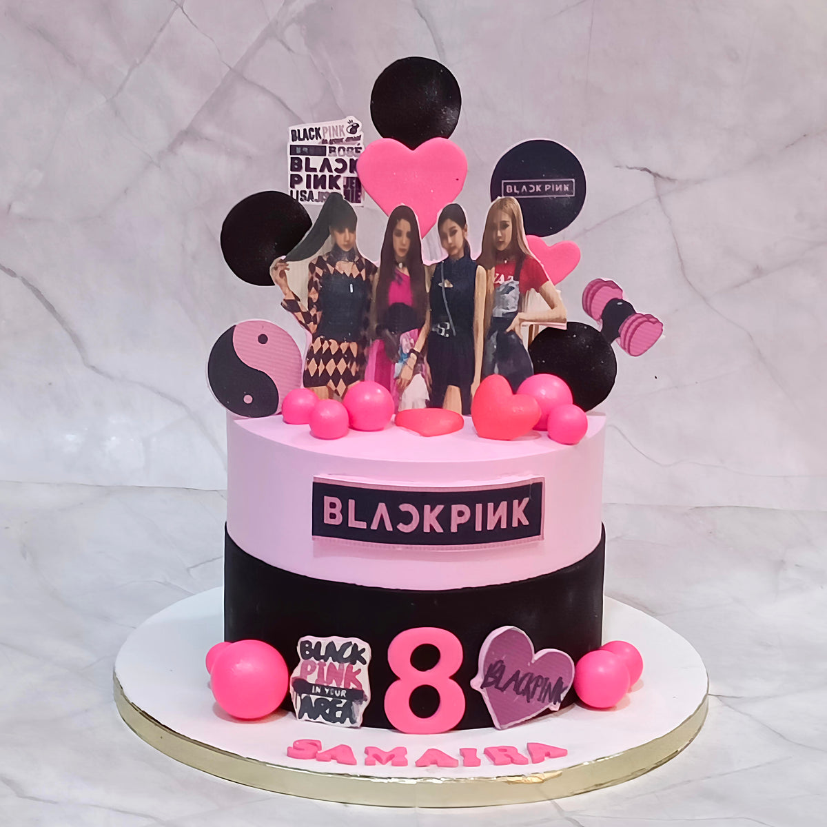 BLACKPINK Jennie-themed birthday cake with pink and black frosting, character cutouts, fondant hearts and faux pink balls.