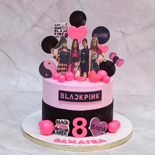BLACKPINK Jennie-themed birthday cake with pink and black frosting, character cutouts, fondant hearts and faux pink balls.
