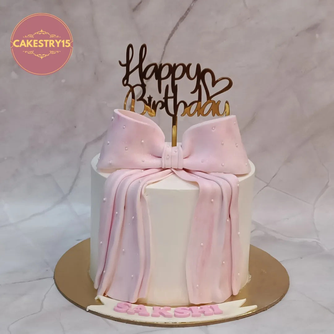 Elegant girls birthday cake with blue bow design, crafted as a premium theme cake Noida customers love for stylish eggless cakes celebrations.