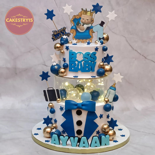 Boss Baby theme first birthday cake with tuxedo design, spacer with lights, logo, and edible elements in eggless choco vanilla by Cakestry15 Noida