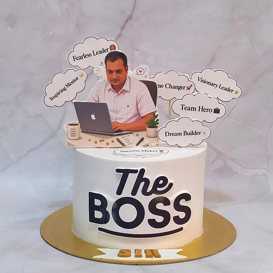 Boss-themed chocolate birthday cake with edible images of a boss working on a laptop, personalised message tags, Boss written on the front and a coffee mug on one side.