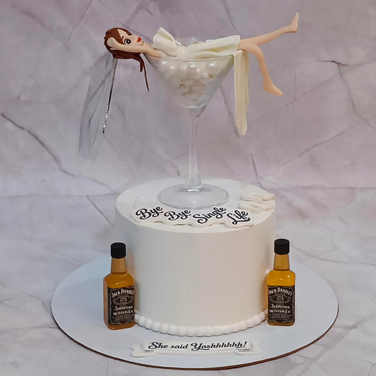 Bride to be celebration cake with a martini glass and figurine, a theme cake in Noida from a bakery specialising in eggless cakes.