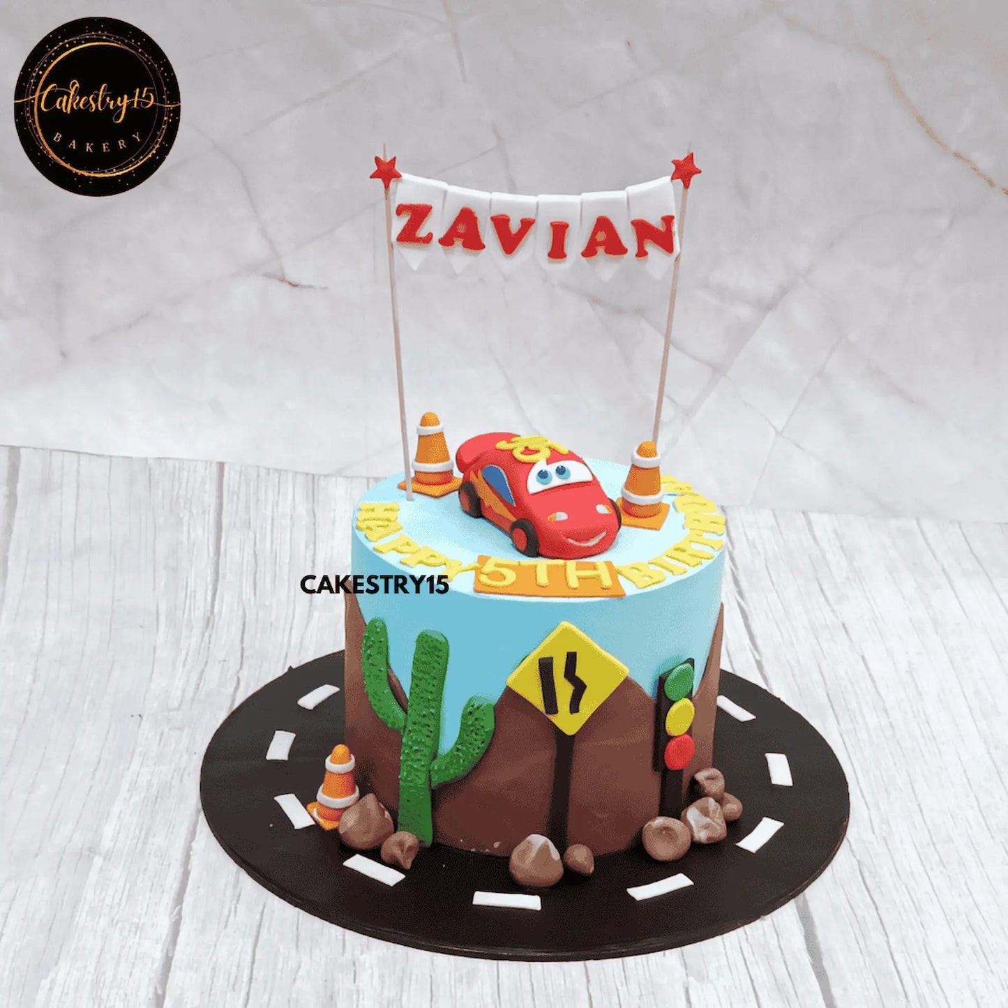 Eggless car theme kids racing birthday cake with fondant car, road design, and personalised name for a 5th birthday in Noida