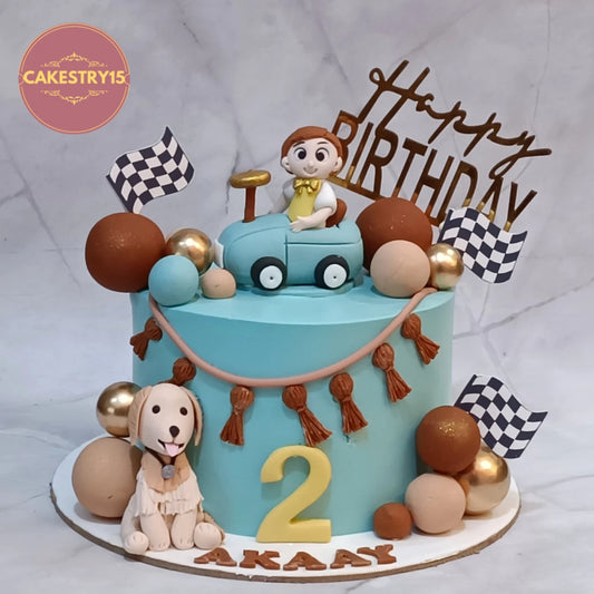 Eggless Car Theme Road Trip kids birthday cake in Noida featuring a kid figurine in a car, racing flags, faux balls, and a dog figurine for a memorable theme cake celebration.