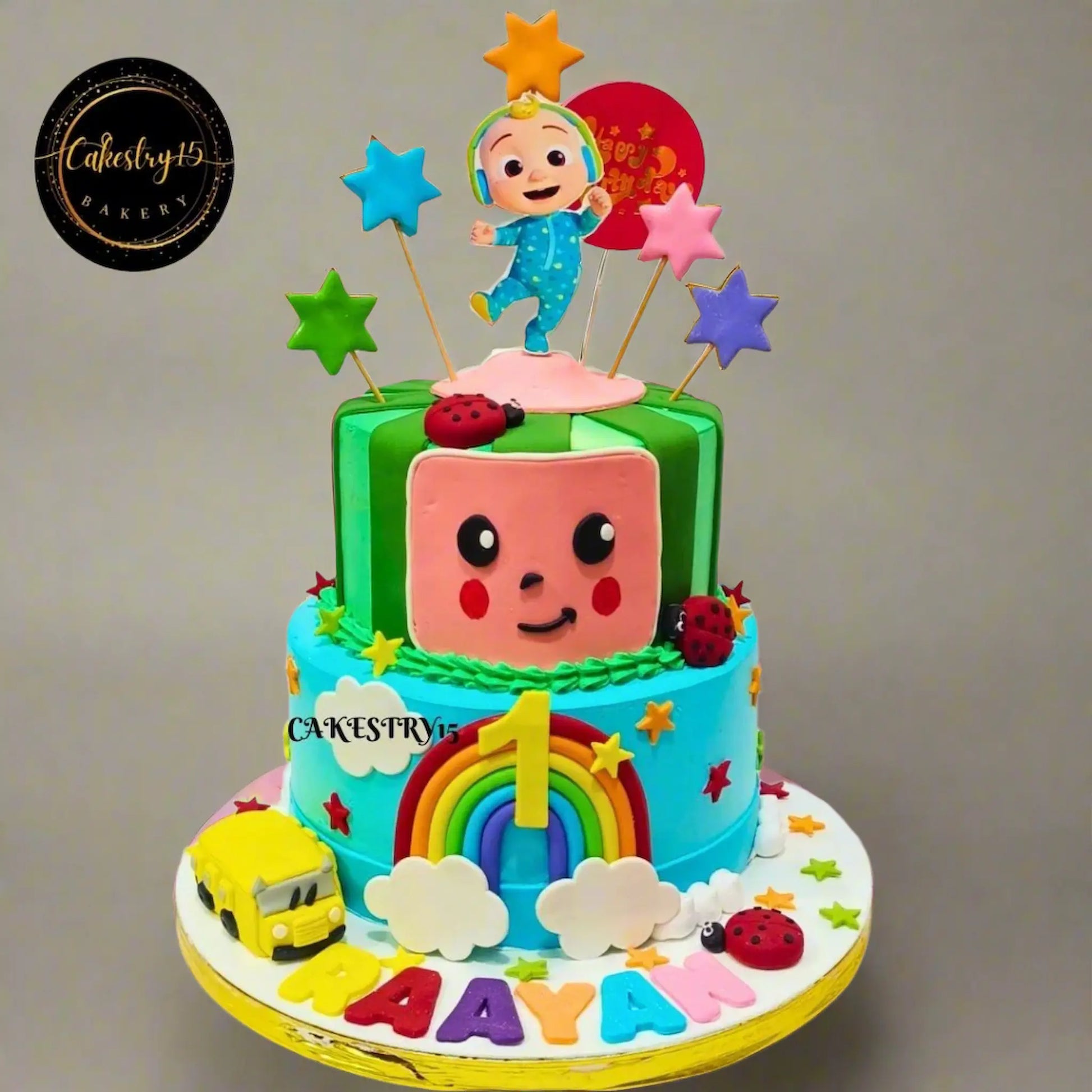 Eggless cocomelon first birthday cake with bus, bugs, clouds and stars for kids birthday celebration in Noida