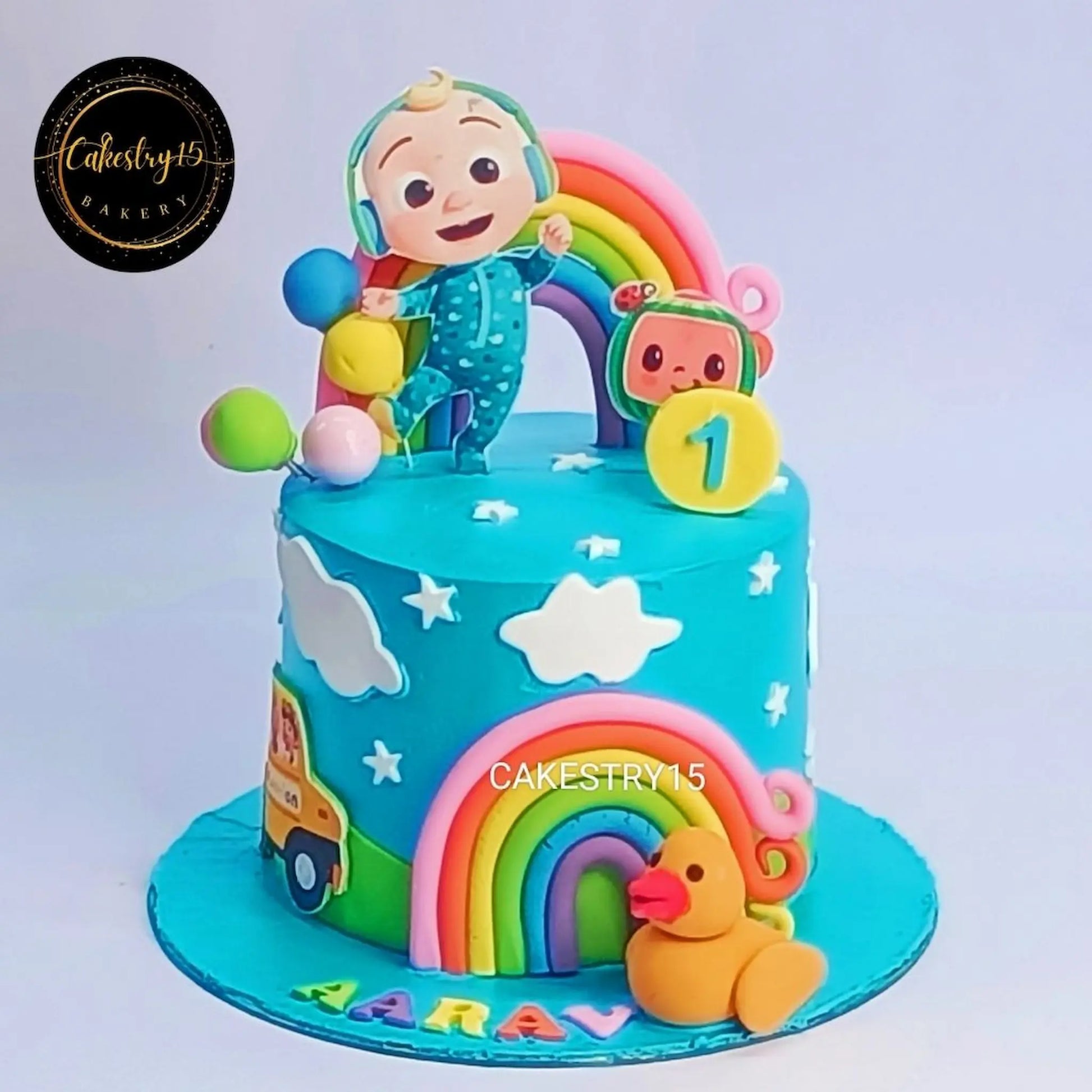 Eggless Cocomelon bus first birthday cake for kids with balloons and clouds design in Noida by Cakestry15