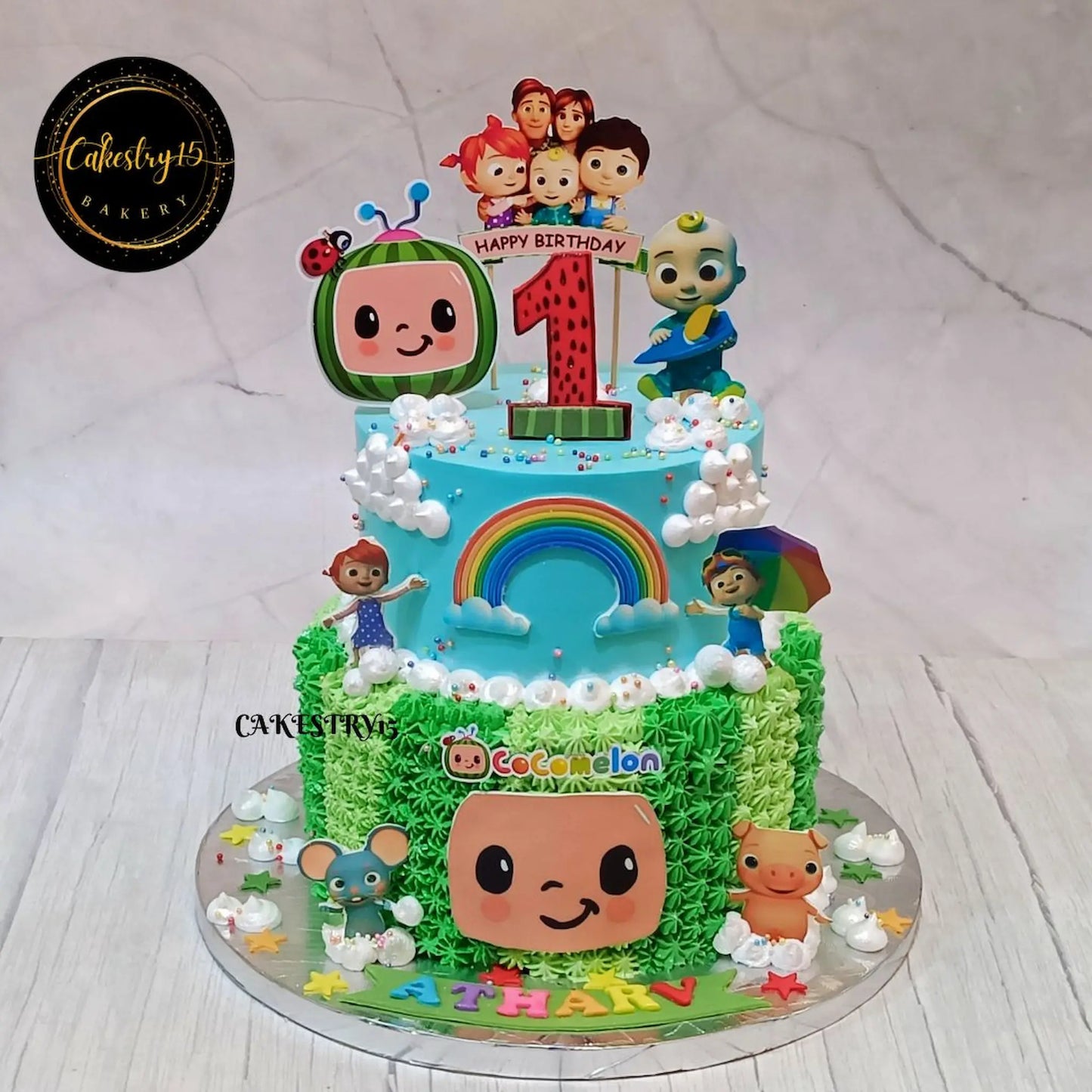 Eggless cocomelon carnival kids first birthday cake with balloons rainbow and characters theme cake Noida for kids birthday celebrations