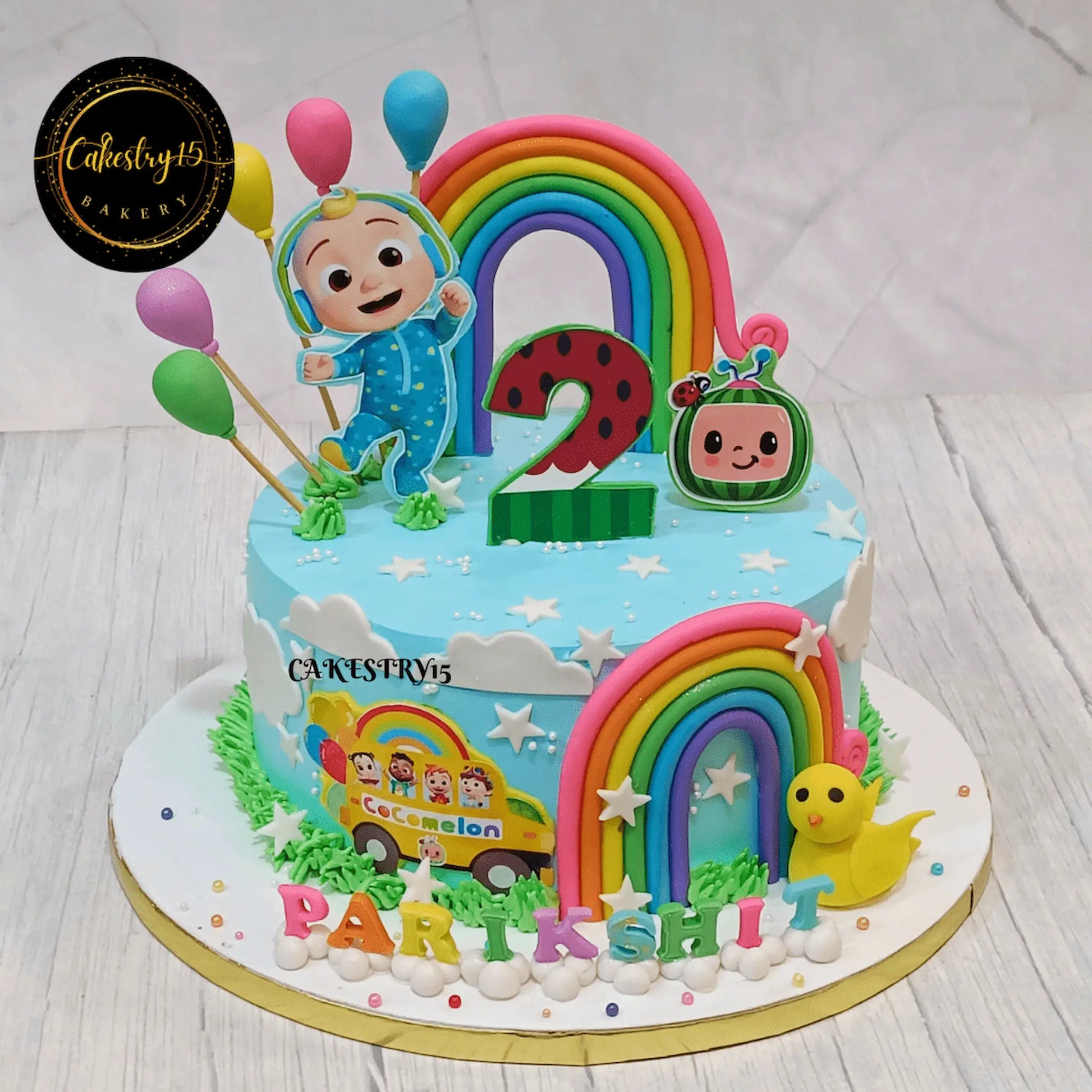 Eggless cocomelon delight pineapple kids birthday cake with rainbow, balloons, duck and edible cocomelon image for 2nd birthday celebration