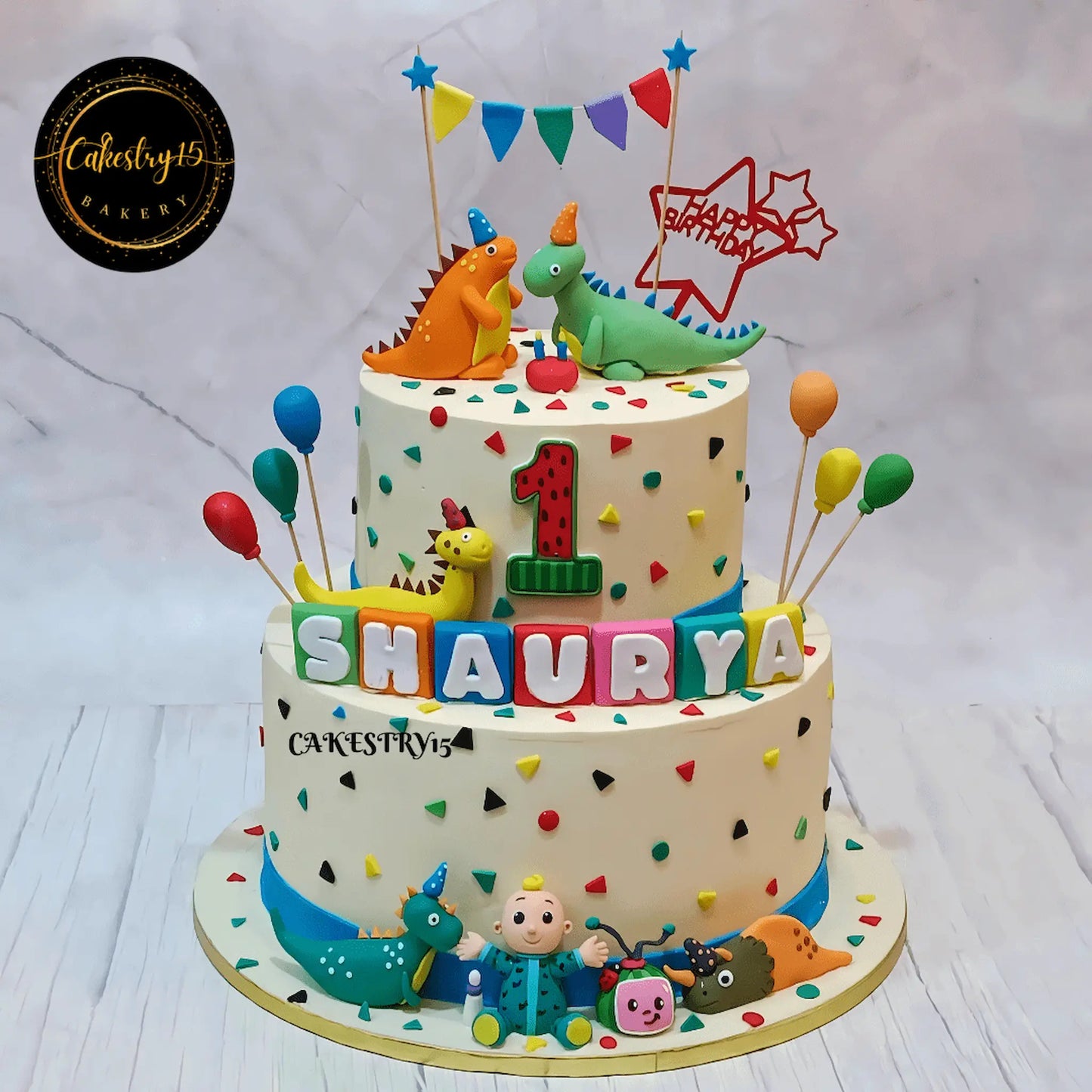 Eggless dino cocomelon first birthday cake in Noida, 7kg chocolate theme cake with 3D fondant dinosaurs and cocomelon design for kids celebration