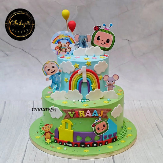 Eggless Cocomelon fiesta train first birthday cake with rainbow balloons pineapple flavour custom kids cake in Noida